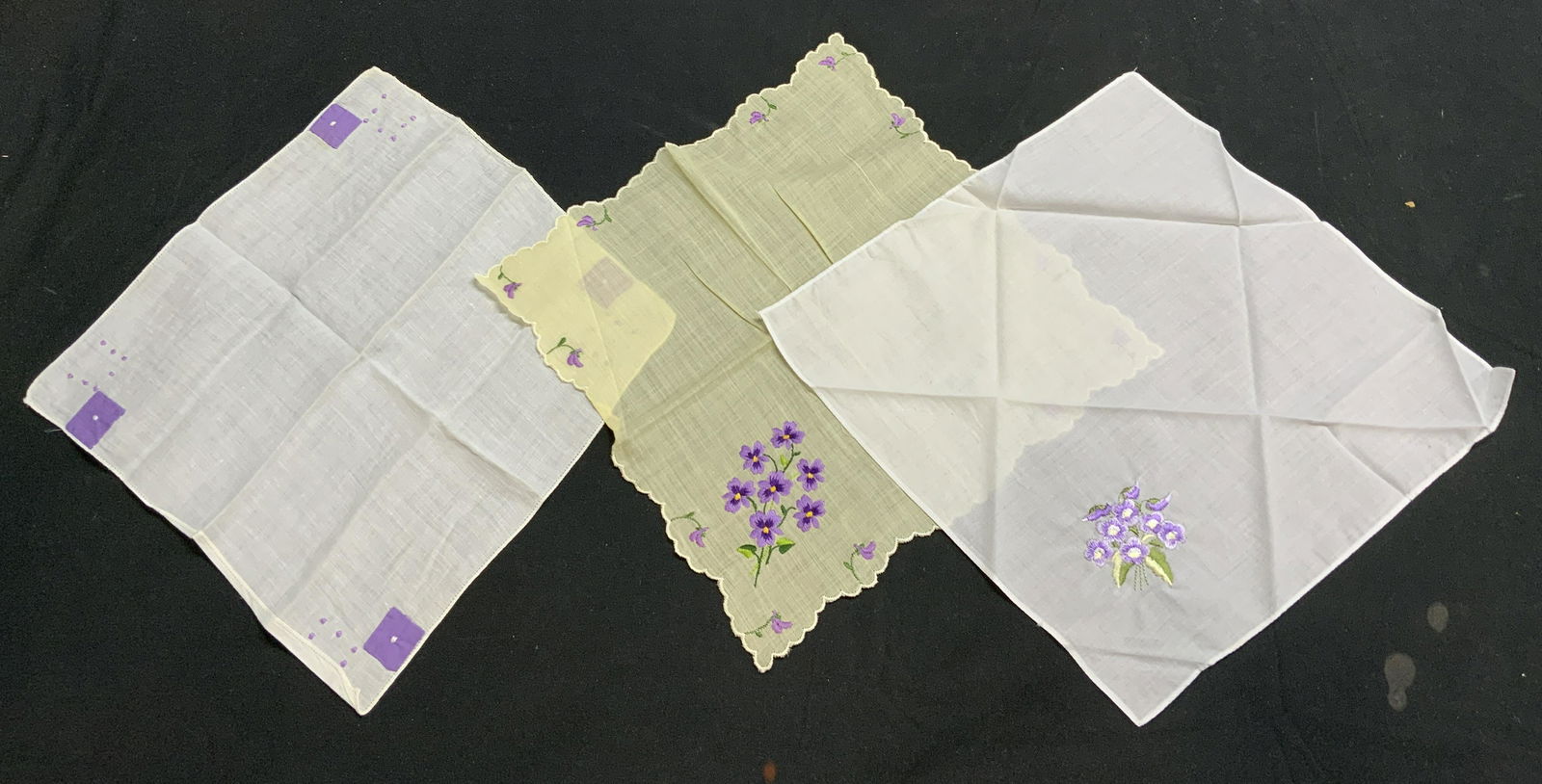 Group 3 Vtg White & Yellow Floral Handkerchiefs: Group of 3 vintage handkerchiefs in white and yellow with purple embroidered decoration. Sizes vary, approx. 11 x 10.75 inches. All pieces have some wear to fabric consistent with exposure. Materials