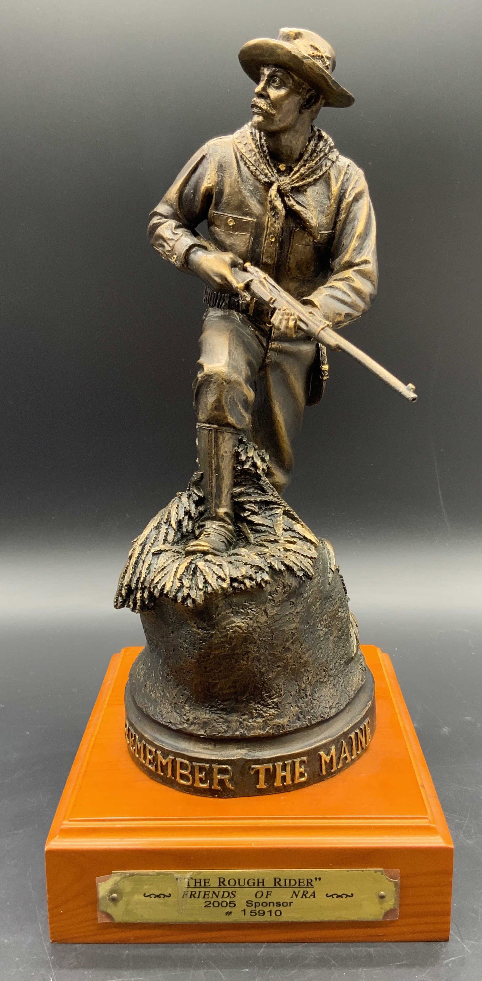 R. Terry THE ROUGH RIDER Friends of NRA Sculpture: Sculpture depicts a man holding his firearm with both hands and looking to the side. Base reads REMEMBER THE MAIN. 2005 Friends of NRA THE ROUGH RIDER Sculpture #15910, with a brass name plate on the 