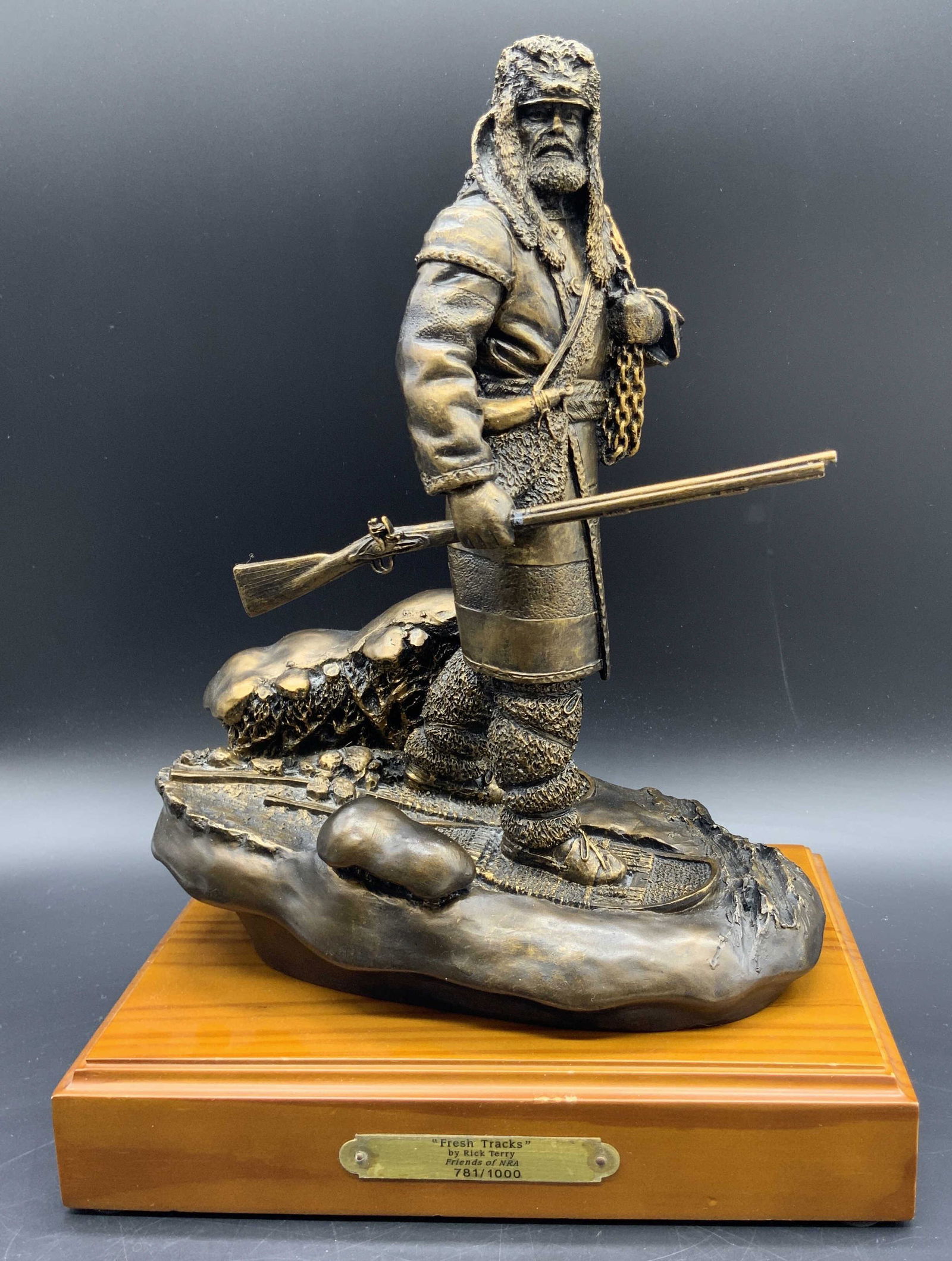 Rick Terry FRESH TRACKS Friends of NRA Sculpture: Sculpture depicts a mountain man holding his firearm and chains. Friends of NRA FRESH TRACKS Sculpture 781/1000, with a brass name plate on the front. Made out of pewter components and a hand applied