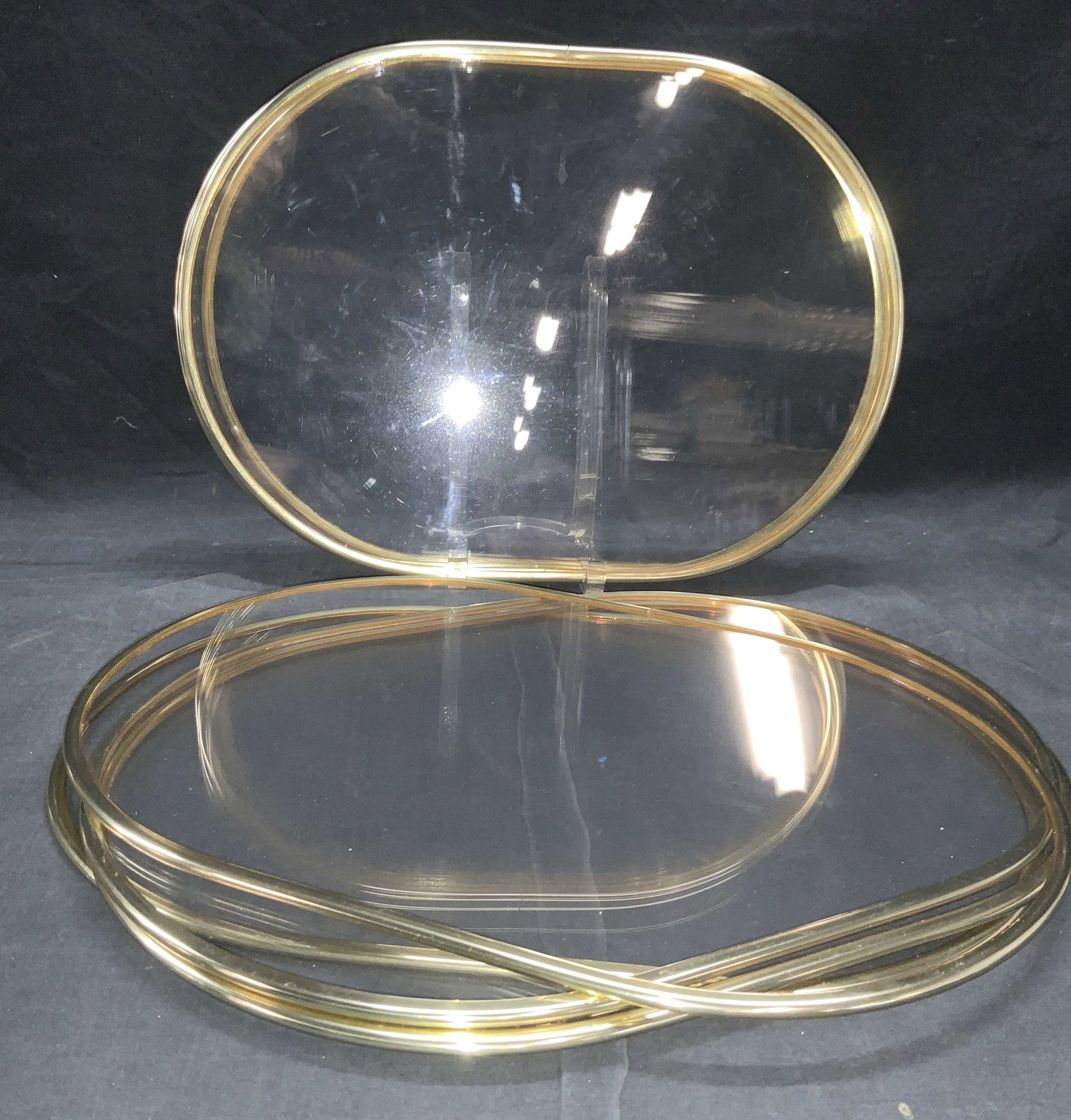 Set 8 Clear Acrylic Placemats w Gold Trim: Vintage Clear Acrylic Placemats, oblong shape with an acrylic gold tone trim. Stored in plastic bag, light surface wear consistent with use. Measure 16.75 x 12 in. Placemats, Table Accents, Homewares,