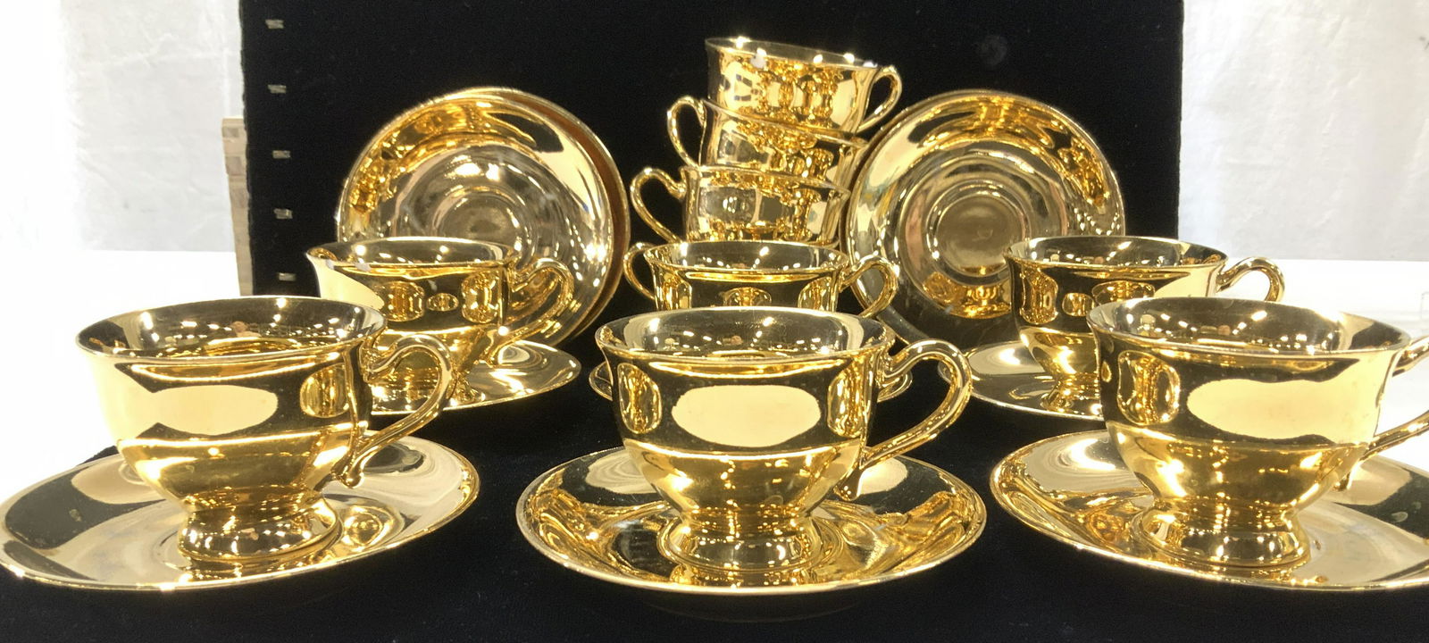 Solid Gilt Demitasse Cup and Saucer Set 20 Germany: Solid gilt over porcelain demitasse set of cups and saucers, hallmarked Made in Germany. Saucers 4.25 in. Cups 2 in ht, 3.25 in total width. One rim chip noted on one cup and one saucer. Picard Style