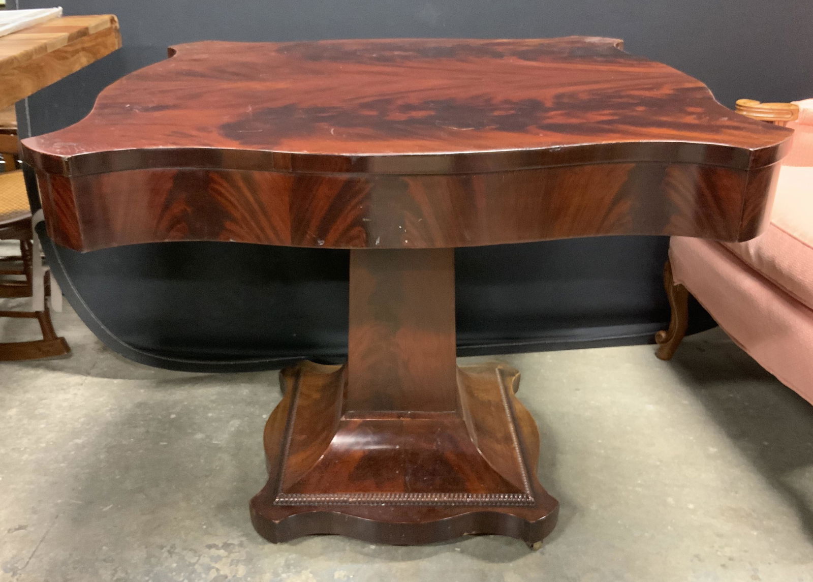 Vintage Wooden Pedestal Table On Casters: Pedestal table is vintage possibly antique. Piece sits on casters. Table is mahogany toned. Measures approx 28.5 inches tall 34 inches wide & deep. Table, table on casters, vintage table, vintage furn