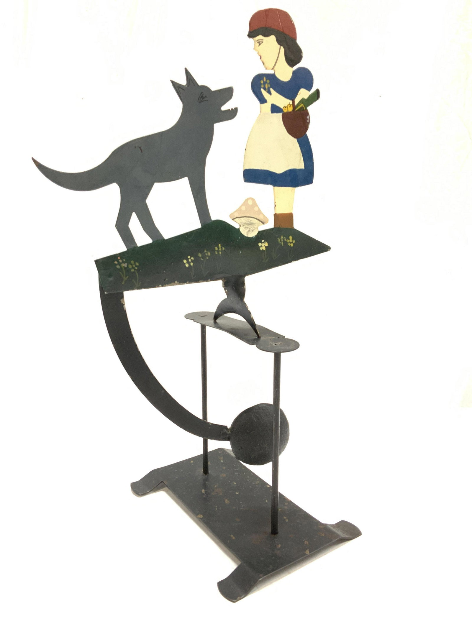 Metal Girl & Wolf Whirligig Folk Art, 2: 2 piece metal whirligig , stand and flat balancing piece depicting a girl carrying a basket and a wolf. Possibly decaying the American Folk tale of the girl who cried wolf. Hand painted. 15. In ht, 9 