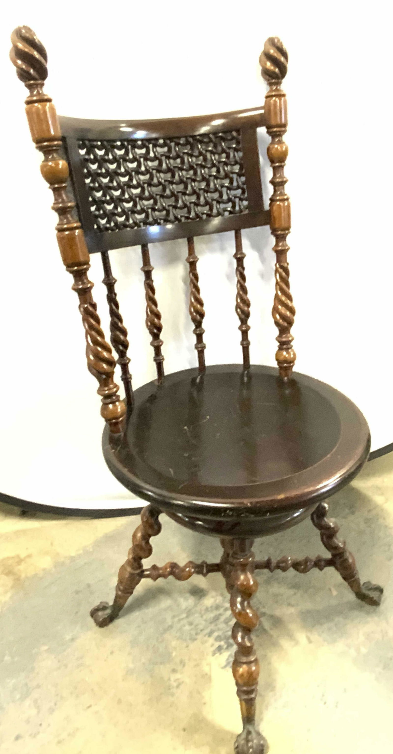 Merklen Victorian Piano Chair Stool Clawed Feet: Attributed to Merklen Brothers Furniture. No labels or hallmarks observed. Hand carved antique wooden piano chair with metal clawed feet. Turned wood detailing and open woodwork. Chair seat swivels. M