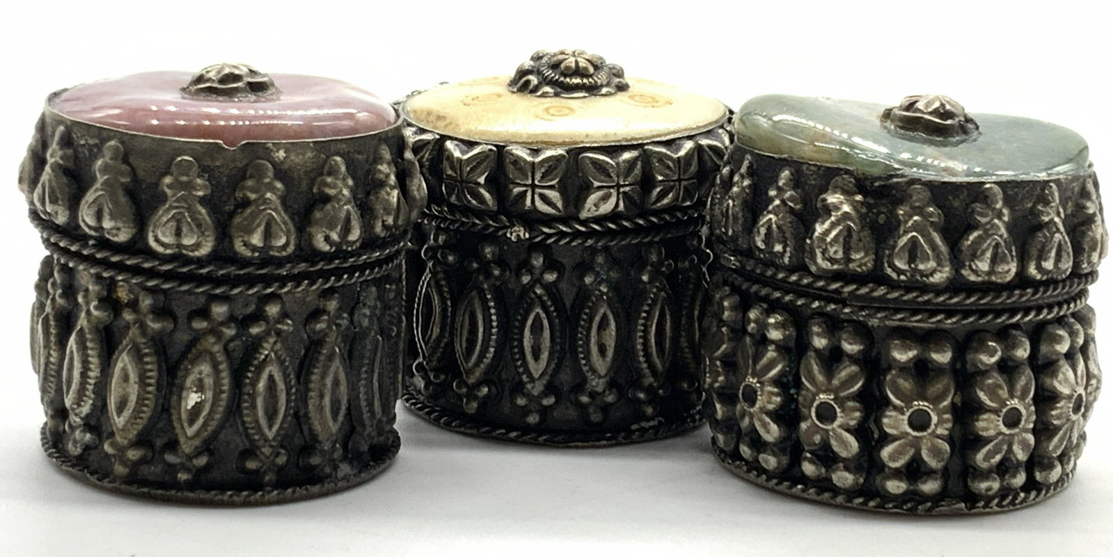 Set3 Vintage Metal & Stone & Bone Trinket Boxes: 3 vintage metal trinket boxes. Embossed on bodies with vertical and floral style motifs. Lids are adorn with similar designs. 2 lid caps are made of natural stone, one green speckled and 1 pink speckl