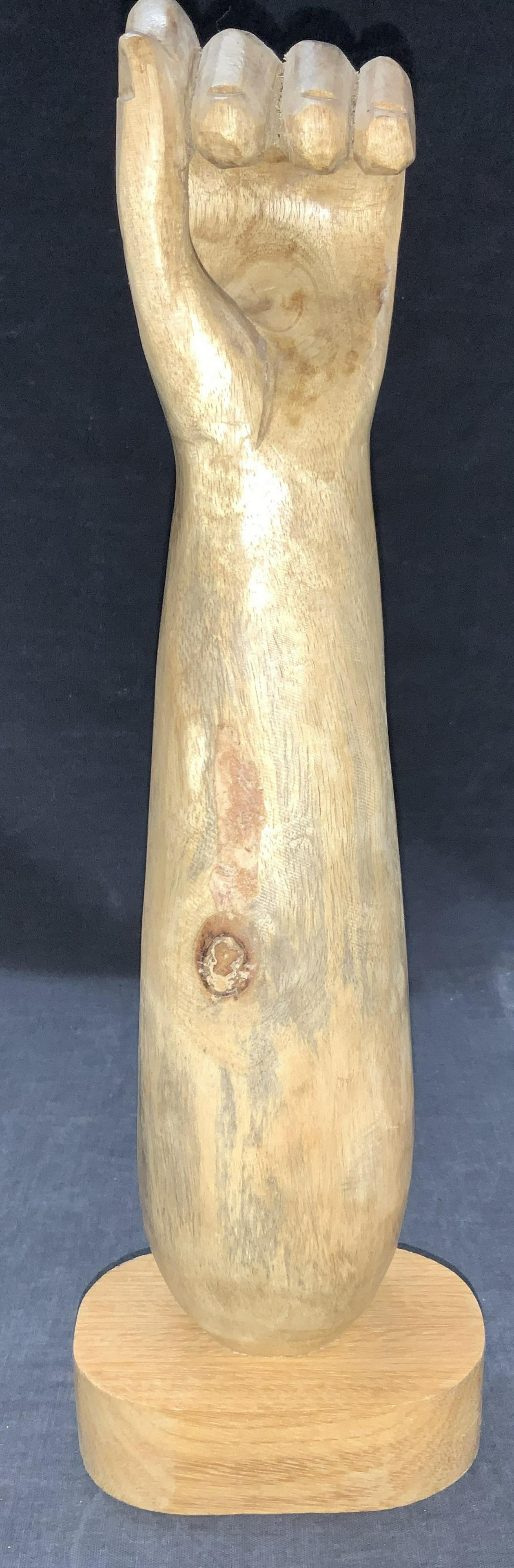 Carved Woden Hand Wall & Tabletop Sculpture: Carve wooden hand with arm sculpture on base. Hand is in a gripping position. Underside of base has wall hanging hardware, or can be displayed upright on a table. Approximately 13 inches tall Minor we