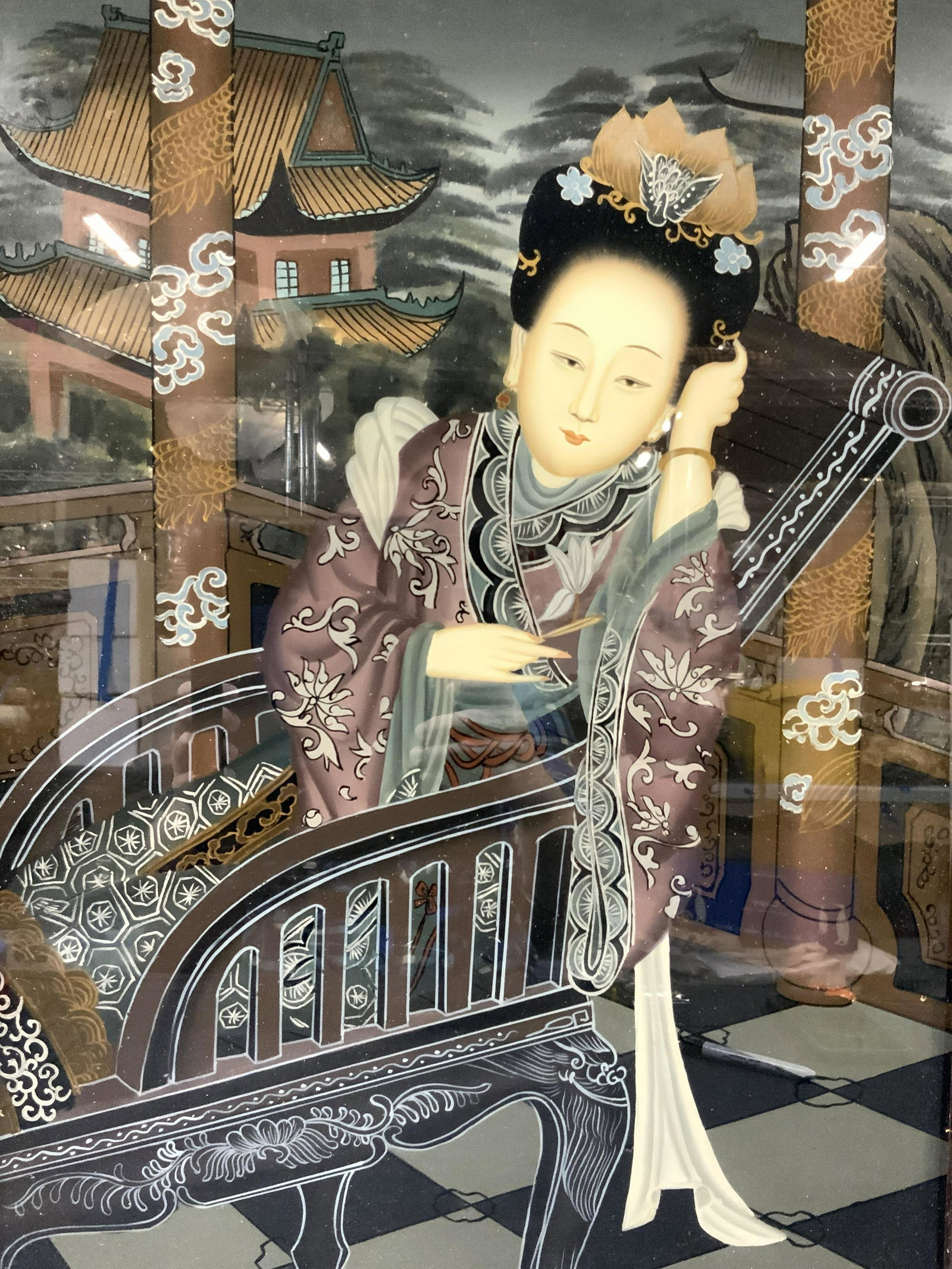 Hand Painted Asian Figural Reverse Glass Painting: Vintage reverse painting on glass Depicting a Chinese noble woman lounging on a black ornate chair, leaning on the arm of the chair and looking at the viewer with dragon columns behind her with temple