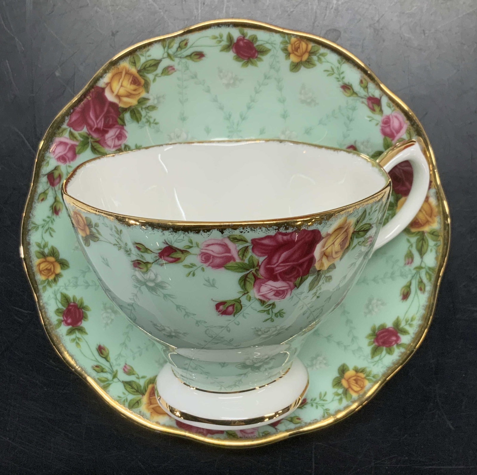 Royal Albert Old Country Roses Porc. Cup & Saucer: Hand Painted mint green porcelain tea cup and saucer with orange and pink roses., Made in England. 24k gold rims, footed tea cup 3.75 x 3.75 in. Saucer 5.5 in. Both hallmarked C. 2002 Royal Albert Tea