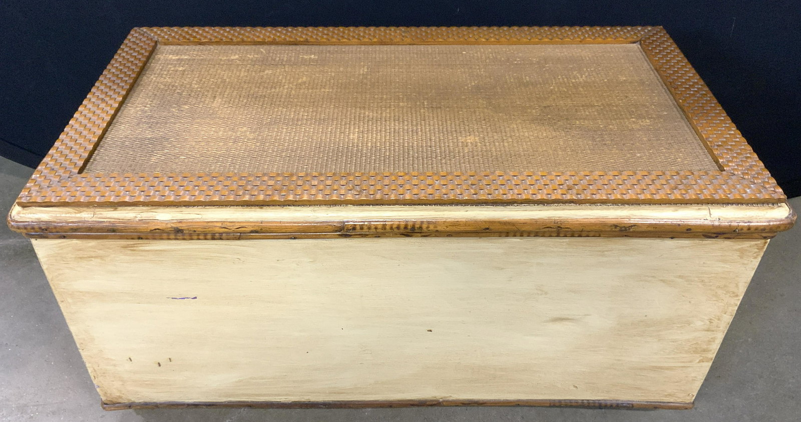 Lidded Caned Wooden Chest On Casters: Chest is wooden possibly veneer. Piece has hinged lid with caning. Chest is cream & beige toned. Piece has casters attached to underside. Chest measures approx 27 inches long 13 inches tall 14.5 inche