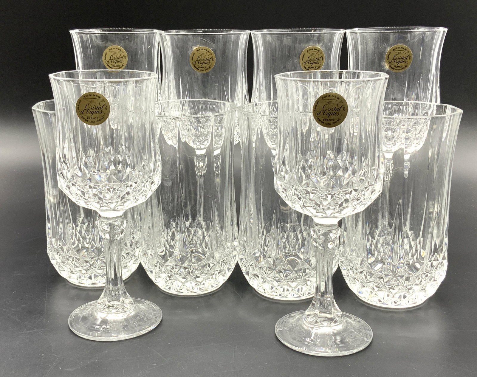 LONGCHAMP CRYSTAL ARQUES Glasses, 23 Org Box: 5 boxes of French LONGCHAMP Lead Crystal d ARQUES Stemware and Tumblers. 24 glasses in total. Various sizes. Cut Crystal with diamond pattern. Many possibly never used and still have original stocker 