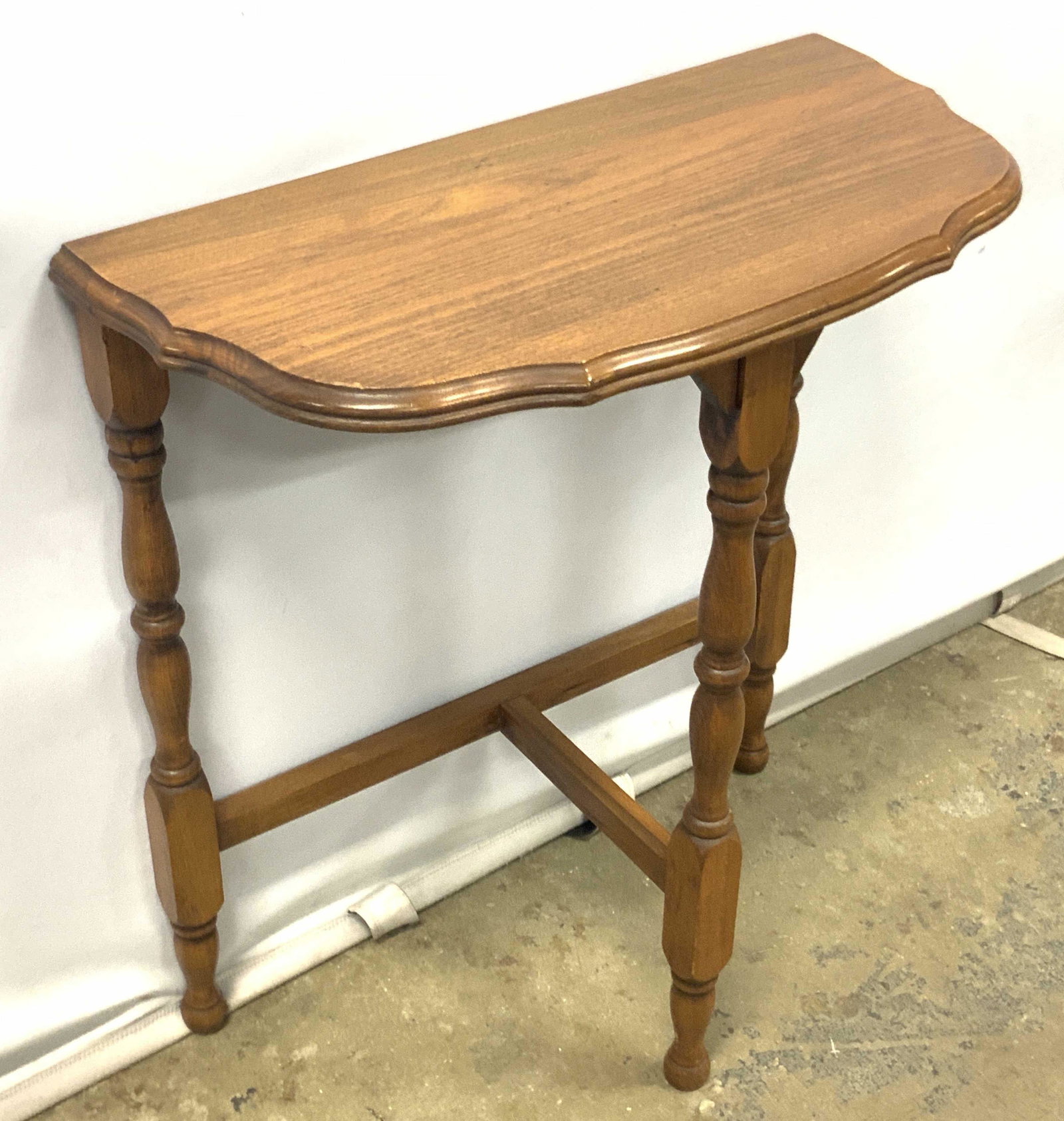 Carved Wooden Demilune Side Table: A carved wooden Demilune/ half moon / Demi lune side table. Three carved legs. Brown finish. Measures approx 23H x 21W x 10D in. Some surface wear consistent with use and age. Demi lune, half moon, de