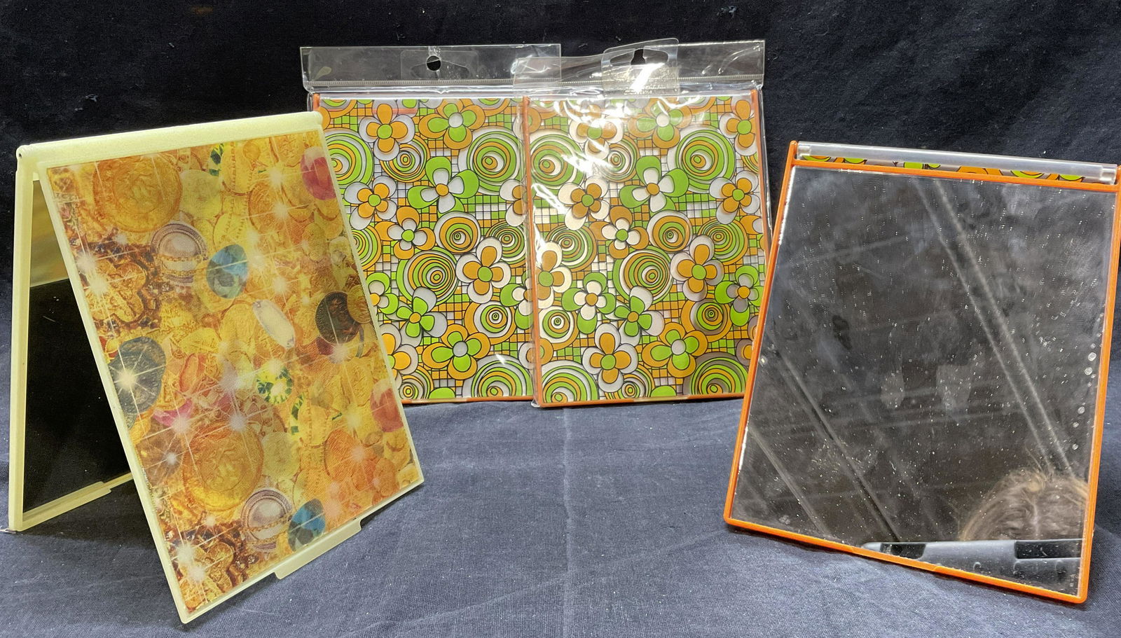 Lot 4 Retro Compact Mirrors: Lot 4 Retro Compact Mirrors. 2 in original packaging. Minimal wear to pieces, consistent with age and use. Measures approx 4.75 x 6.5 inches. 3 compacts with 70s style floral detail and 1 with pinup m