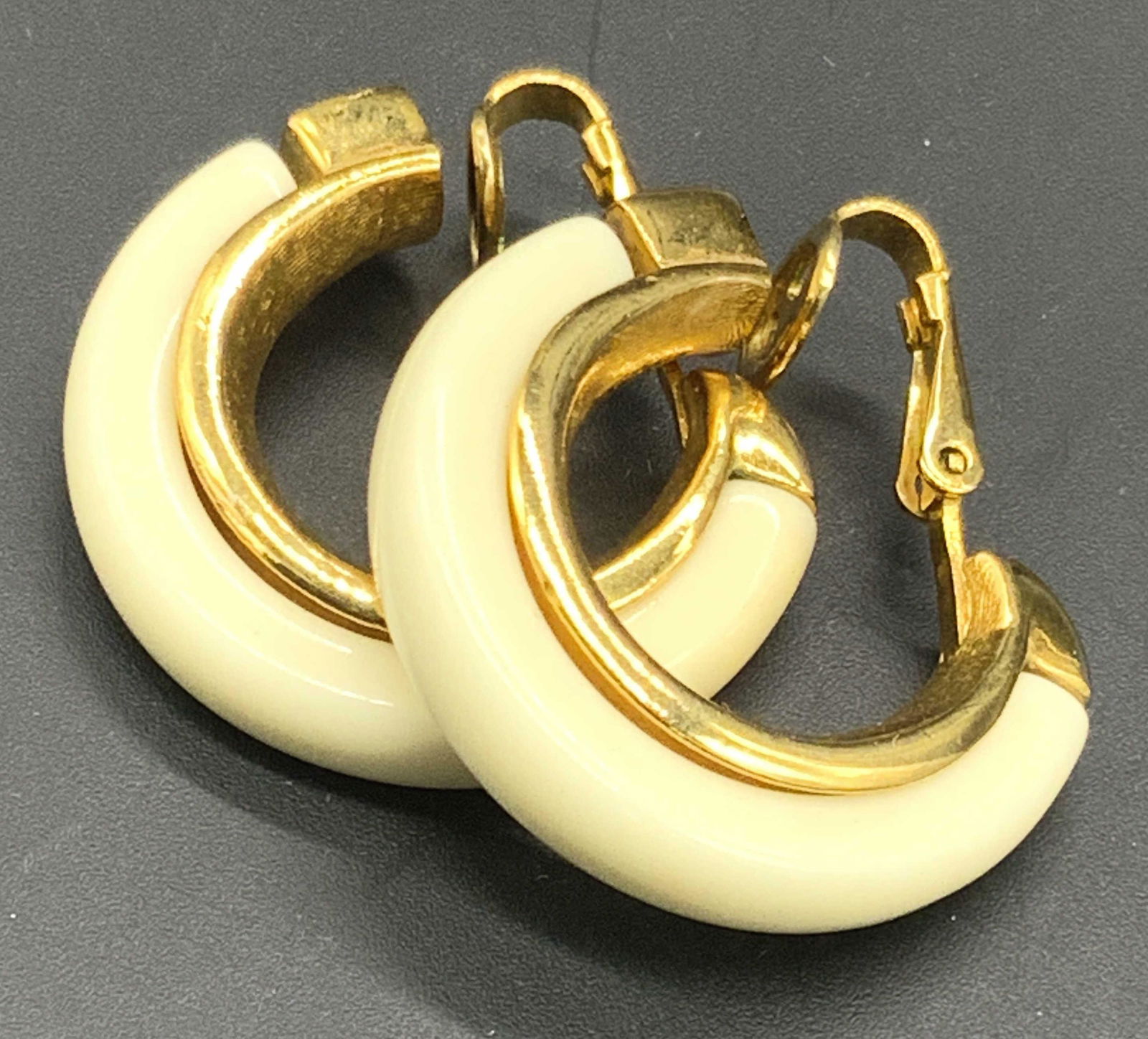 TRIFARI Vintage Hoop Clip On Earrings, Jewelry: Vintage gold tone metal hoop clip on earrings. White hued bezel set composite bead to piece. Signed TRIFARI on earring backing. Measures approx 1L x 1W in. Some wear consistent with use and age. Beads