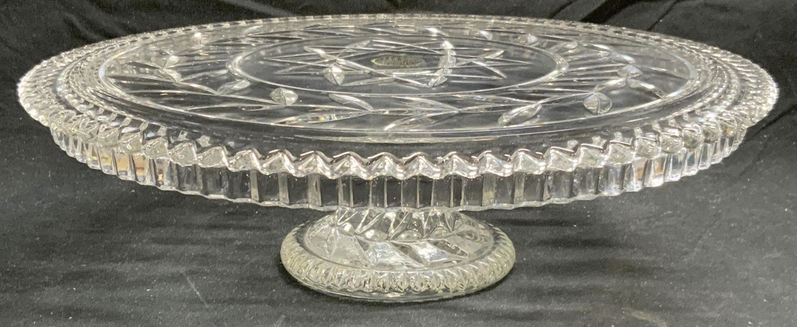 Thick Cut Glass Footed Cake Stand: Thick cut glass footed cake stand. Some surface wear consistent with exposure. Measures approx. 12.5 inches diameter and 3.75 inches tall. Cake stand, glass cake stand, Serveware, kitchenware, tablewa