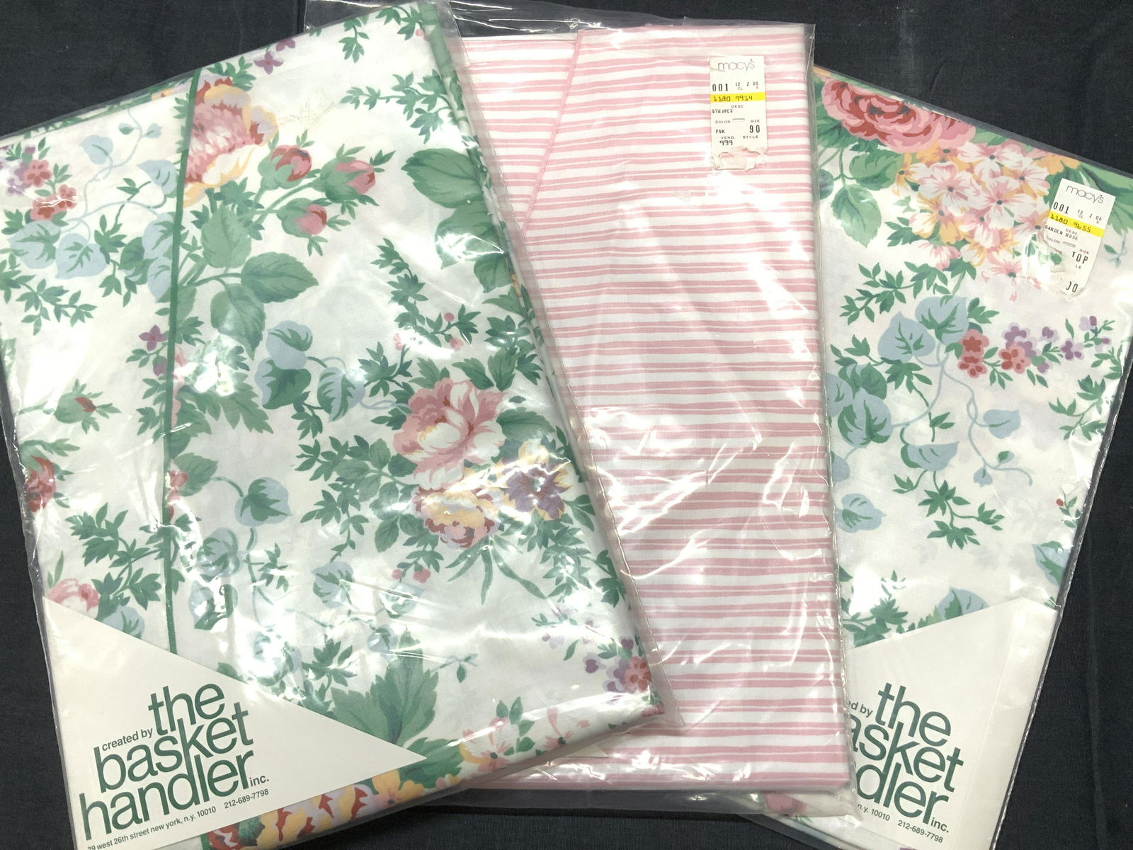 Lot 2 The Basket Handler Sq/Round Tablecloths, NIP: Smooth cotton table clothes, New In Package Square and Round , bought at Macys Department store. Two are the Garden rose print, white with large pink Ralph Lauren Style Roses , green trim. 90 in round