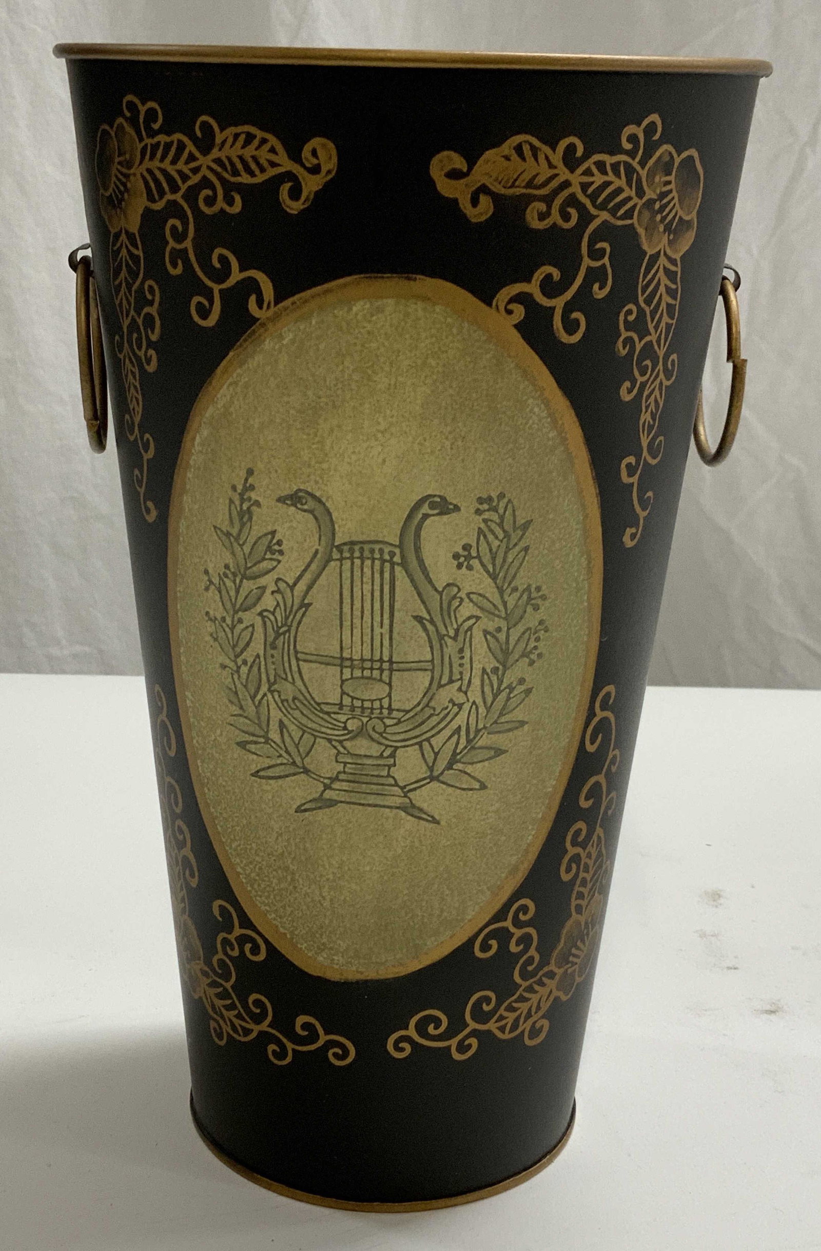Black & Gold Metal Umbrella Stand: Black and gold painted metal umbrella stand with harp motif. Measures approx. 5.5 inches diameter and 9.5 inches tall. In good condition. Umbrella stand, umbrella holder, black umbrella stand, floor a