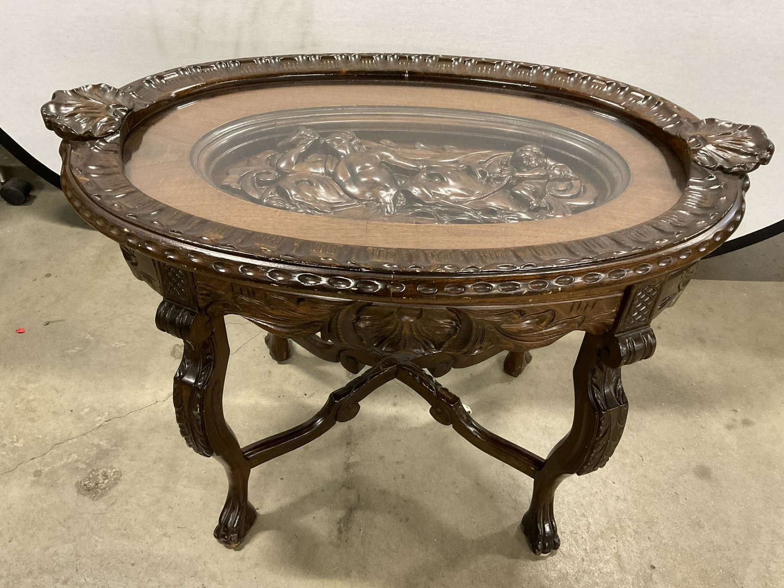 Ornate Carved Wood Side Table W Glass Protector: Ornate Carved Wood Side Table W Glass Protector. Measures approx 31W x 23H x 20D. Top comes off to reveal relief. (See photos). Carved Animal feet. Minor wear to piece, scuffs to surface, and cracks t