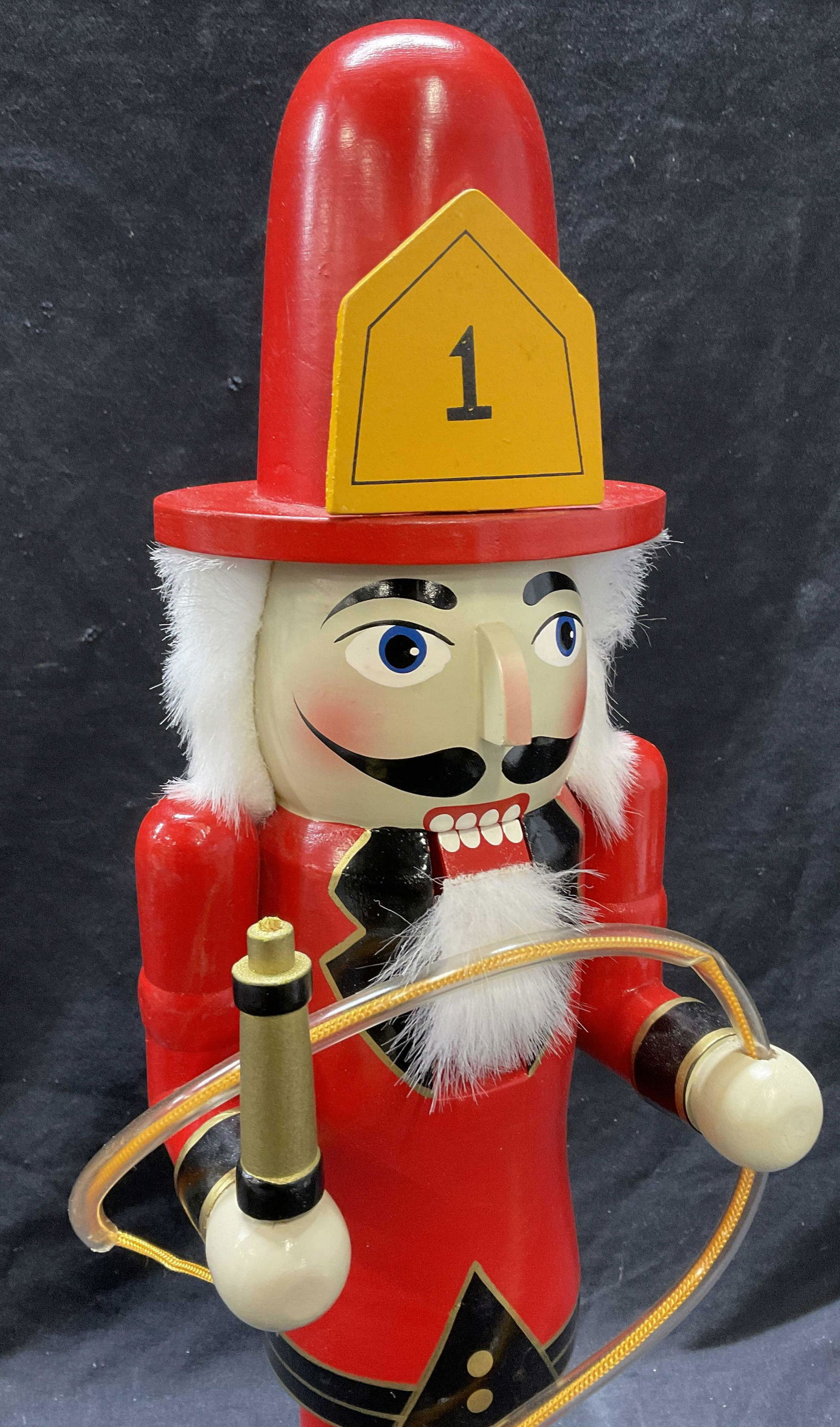 Fireman Nut Cracker Holding a Hose: Fireman Nut Cracker Holding a Hose. Measures approx 20 x 6 inches. Some minor wear to piece consistent with age. Hose is to piece seems to be detached from hand. Nut cracker, fire man nut cracker, hol