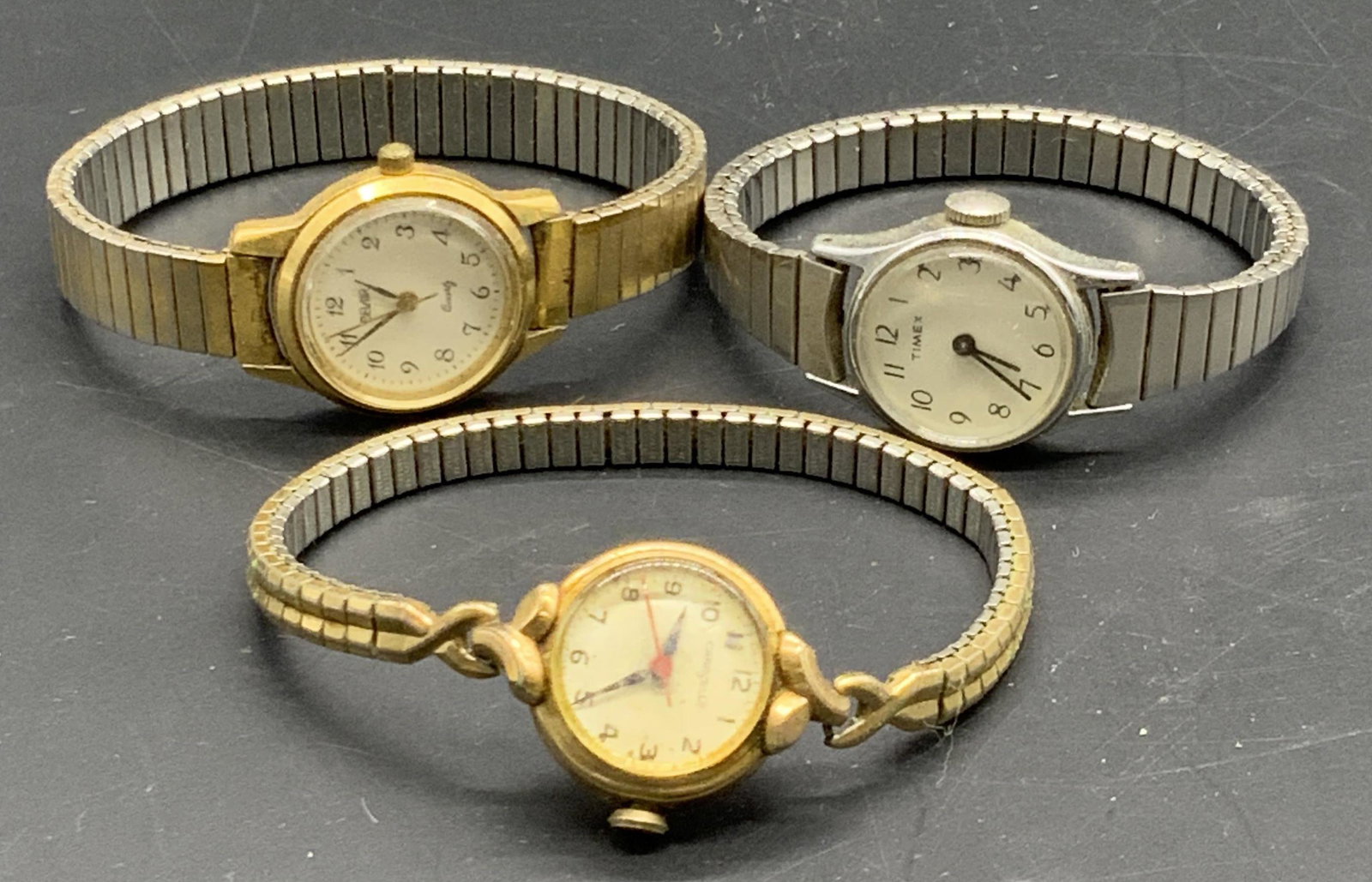3 BELAIR, TIMEX, CARAVELLE Stretch Wristwatches: Vintage wristwatches. Silver and gold tone metal. Some stainless steel elements. Stretch bands. Brands include Belair, Timex, and Caravelle. Bands stretch, approx diameter into stretched is 2.25 inche