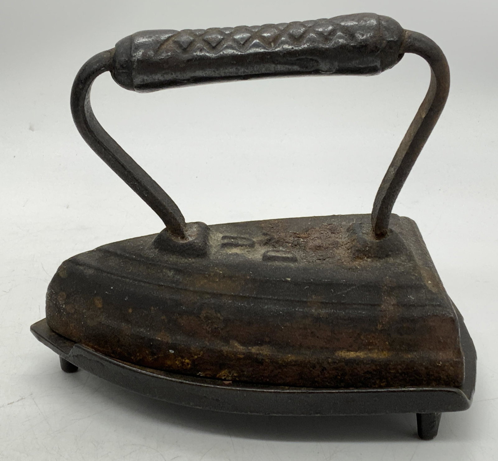 UDX Antique Grip Handle Sad Iron & Stand: UDX marked antique cast iron sad iron with grip handle and stand. Sad Iron measures approx. 5.5 x 3.5 x 4.25 inches. Stand measures approx. 6.25 x 4 inches. Surface wear consistent with age and exposu