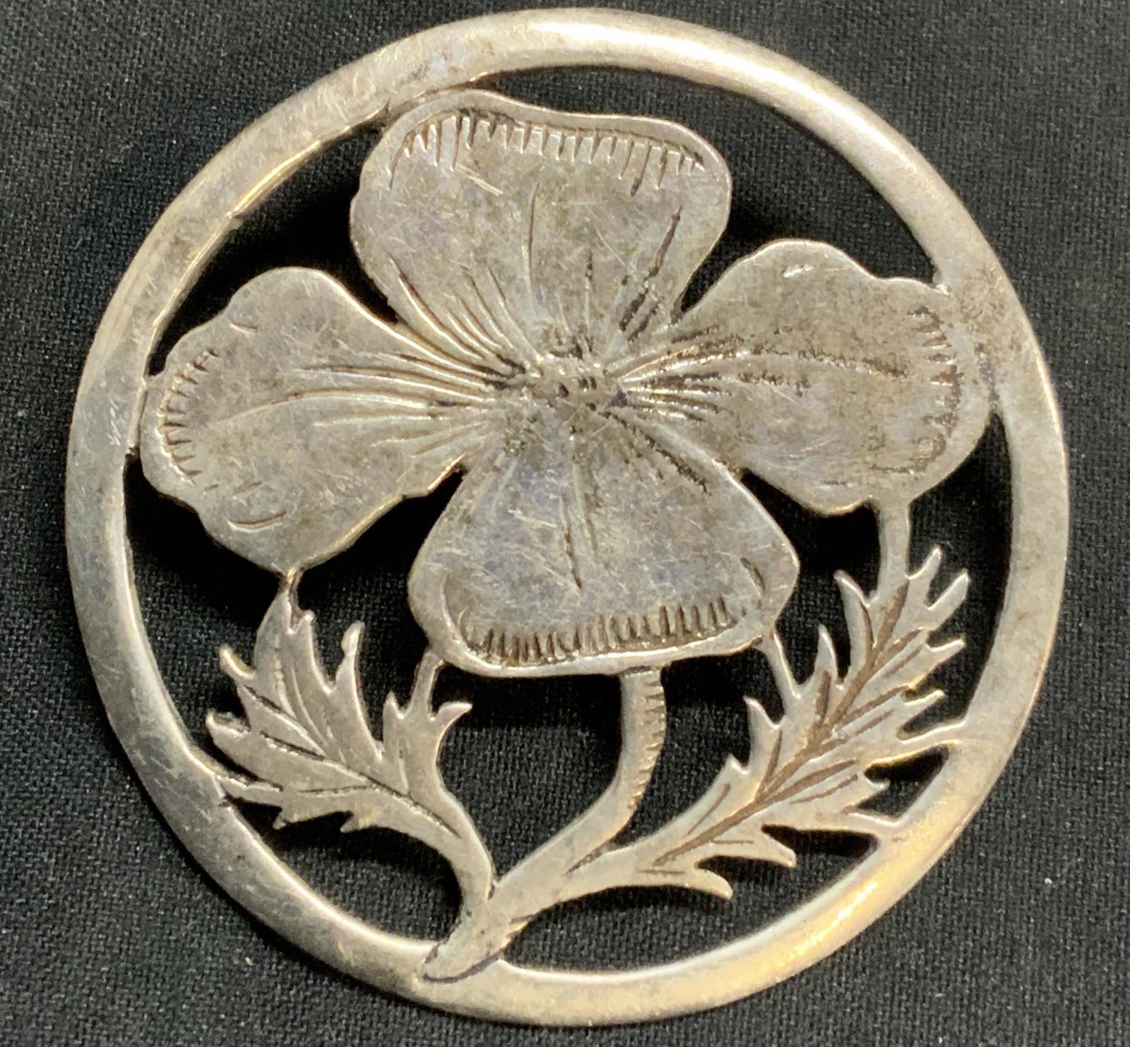 Silver Tone Floral Brooch: Silver tone metal brooch with floral motif. Hinge pin and catch fastener. Measures approx. 1.25 inches diameter. Some surface wear consistent with exposure. Estate jewelry, costume jewelry, cocktail j