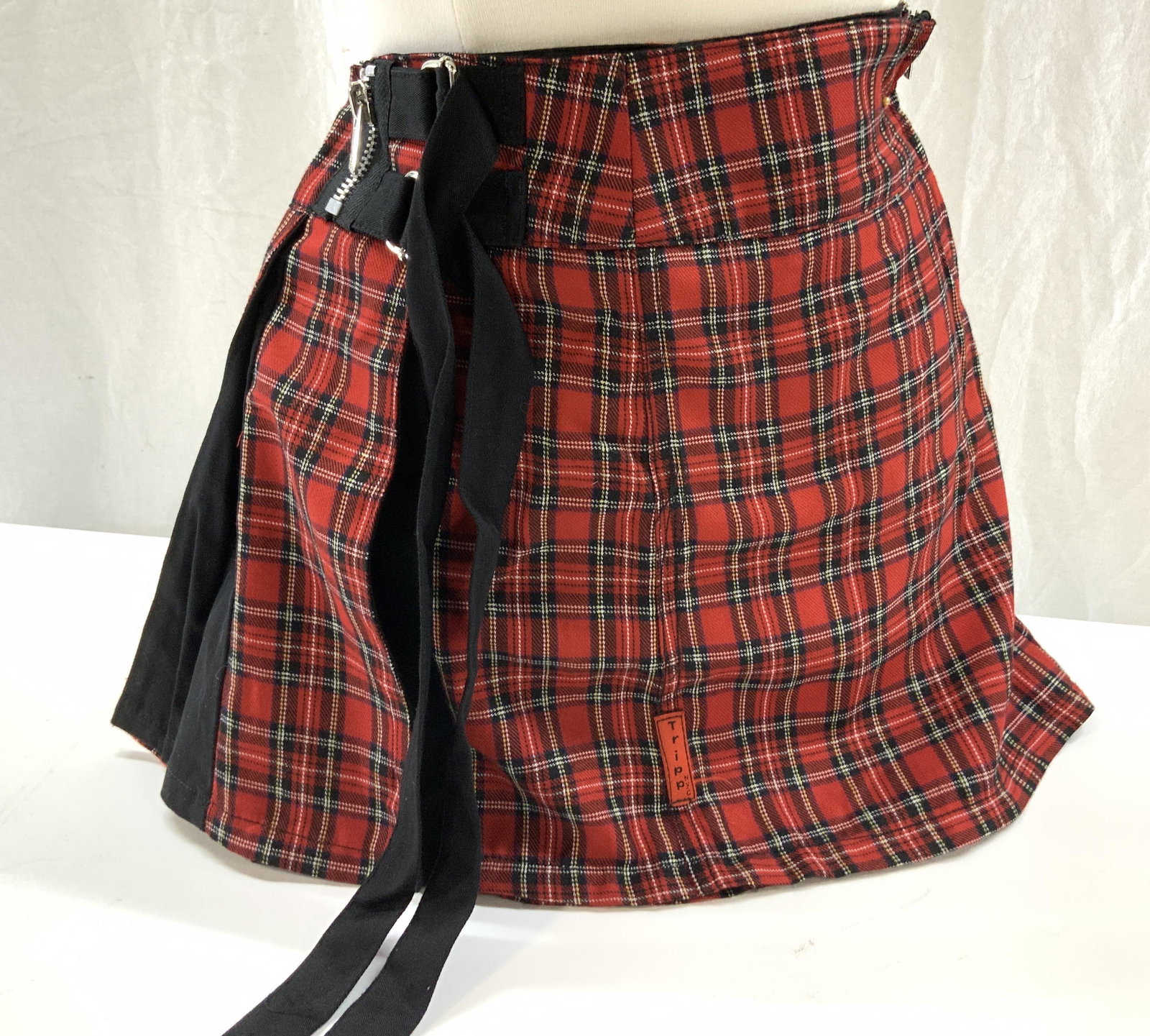 TRIPP Boutique Fashion Plaid Skirt, Sm: Vintage Plaid Mini Skirt , red, black and white plaid with pleating, side zippers and loop belts. Size small. Designer label reads Daang Goodman Tripp NYC . 65% polyester, 35% Rayon. 14 in. Long, wais