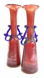 Pr MURANO Hand Blown Iridescent Glass Vases Italy: Ruby red hand blown glass vases with cobalt blue handles, iridescent glass, each a little different in ht due to nature of being hand blown. Taller measures 11.75 in. , 3.5 in wide. Sticker under one