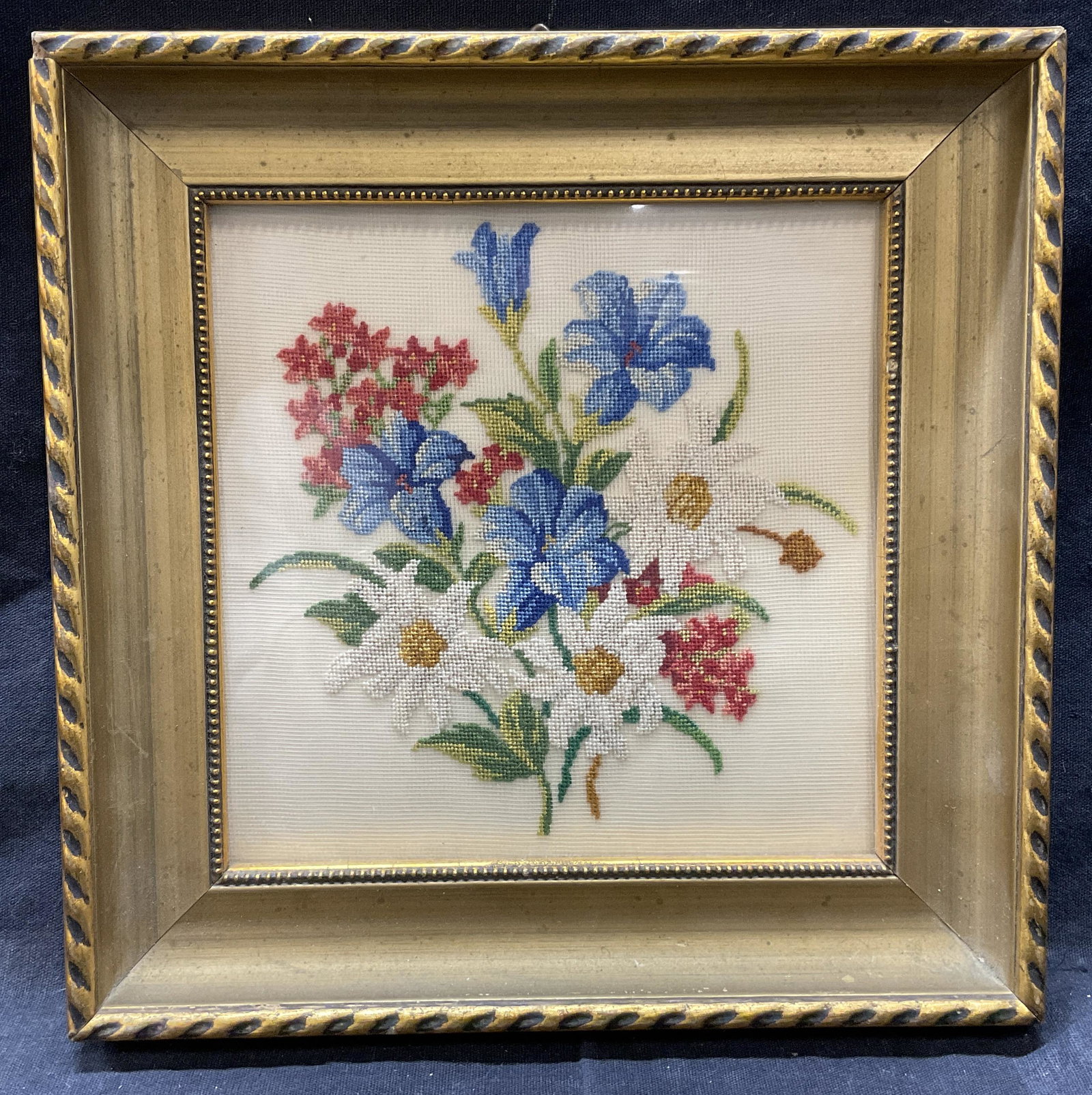 Framed Embroidered Floral Bouquet: Framed Embroidered Floral Bouquet. Whole measures approx 7 7/8 x 7 7/8 inches, window measures 5.5 x 5 3/8 inches. Framed in a gilt frame, embroidery behind glass. Slight surface wear to frame. Not ex