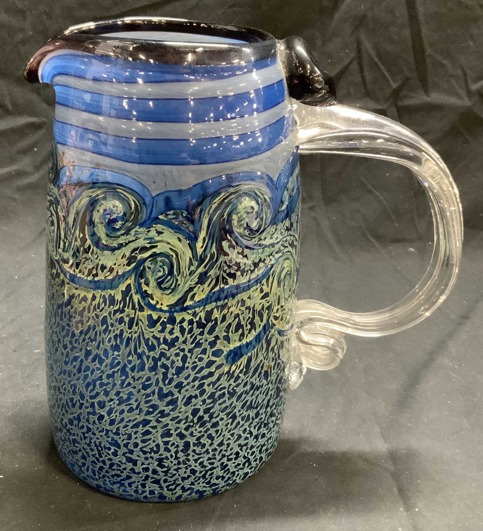 HENRY LEVINE Art Glass Pitcher: Signed Henry Levine Theon Ridge Studio Art glass pitcher in hues of blue and green. Swirling and striped patterns. In good condition. Measures approx. 4.25 inches diameter and 7.75 inches tall. Henry 