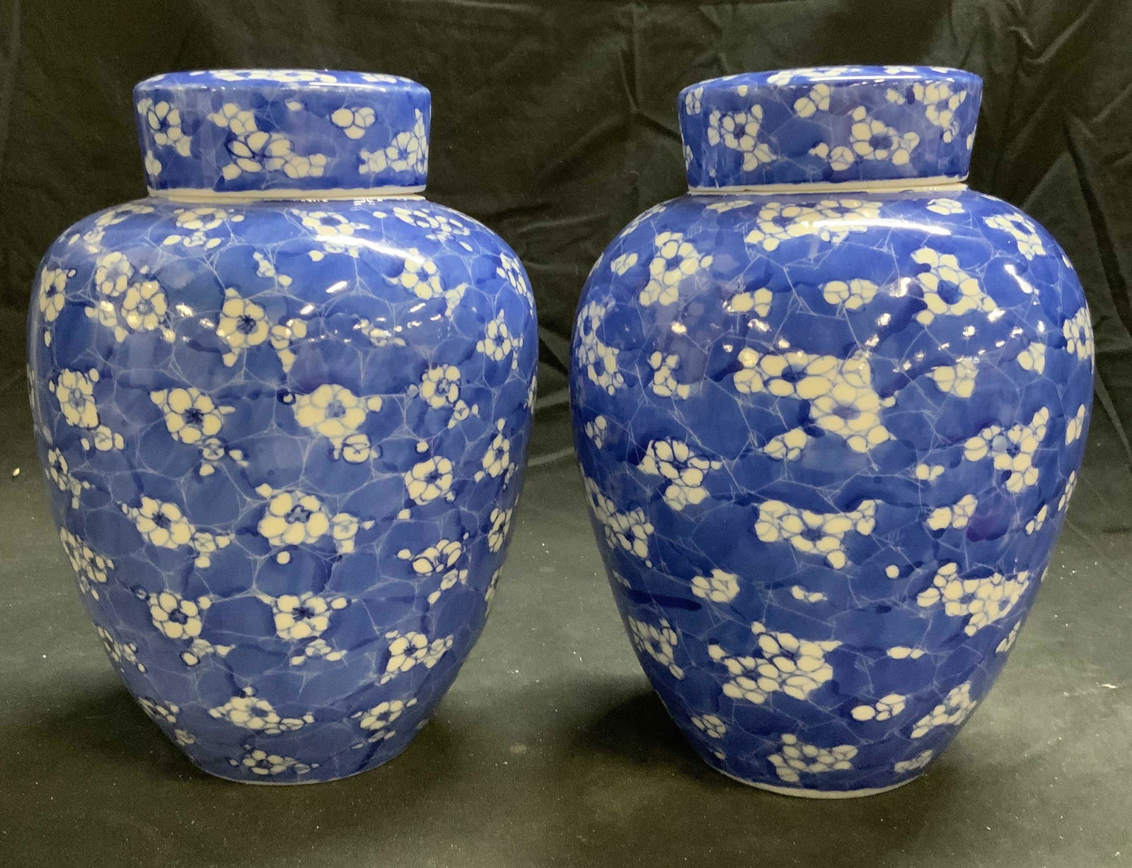 Pair Blue & White Floral Porcelain Ginger Jars: Pair of Asian blue and white porcelain ginger jars with floral motifs. Both pieces in good condition. Measure approx. 7 inches diameter and 10 inches tall each. Ginger jar, porcelain ginger jar, blue