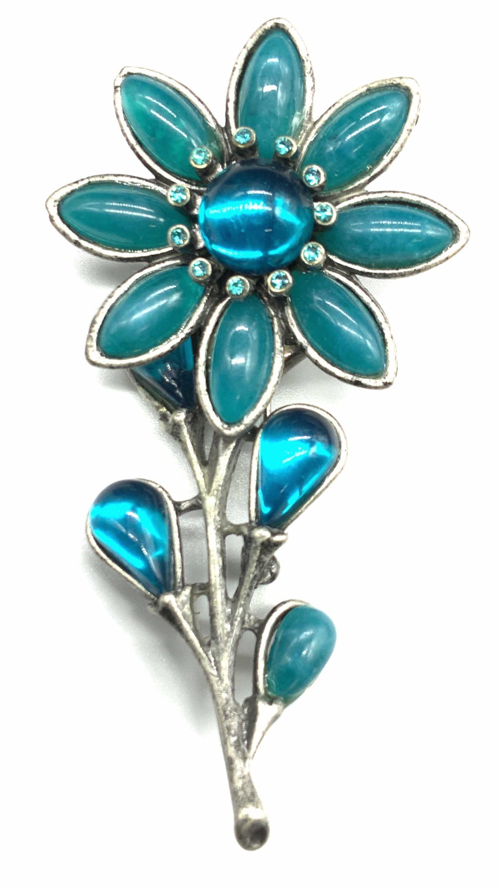 Chunky Teal Flower Brooch Jewelry: Vintage teal flower brooch set in pewter toned metal. Clear glass and opaque resin beads. Contracting colors between the vibrant teal and the pewter tone. Measures 3 x 1.5 in.,3/5 in depth. Luxury Sta