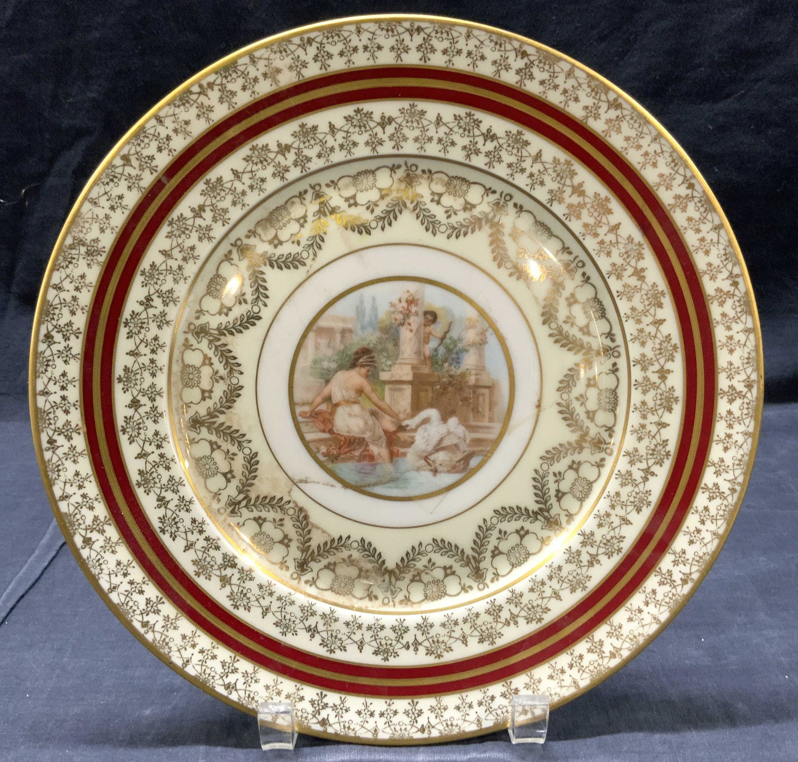 BOHEMIA Porcelain Plate W 22 K Gold Czech: Underside is marked BOHEMIA MADE IN CZECHOSLOVAKIA WARRANTED 22K GOLD. Center of piece depicts a female figure with swan and cherub figure. Possibly depicting Leda and the swan and cupid. Edges have i