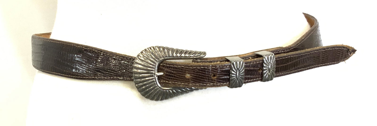 Douglas Magnus Chacon Sterling Buckle Lizard Belt: Signed Douglas Magnus designer brown Lizard Chacon leather belt, signed sterling silver buckle reads Douglas Magnus. Total length 40.5 in., width 1 5/8 in. Prong holes begin and end at 31.75 in. 35 in