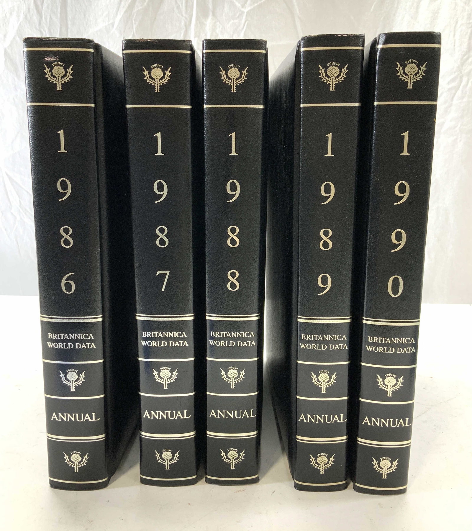 Set 5 Britannica World Data Annual Books: Britannica World Data Annuals, dates are 1986-1990. Encyclopaedia Britannica, Inc. Chicago. Set 5 books measures app 11.5 x 9 x 1.5 in. Gilt page edges. Black leatherette covers. Covers everything fro