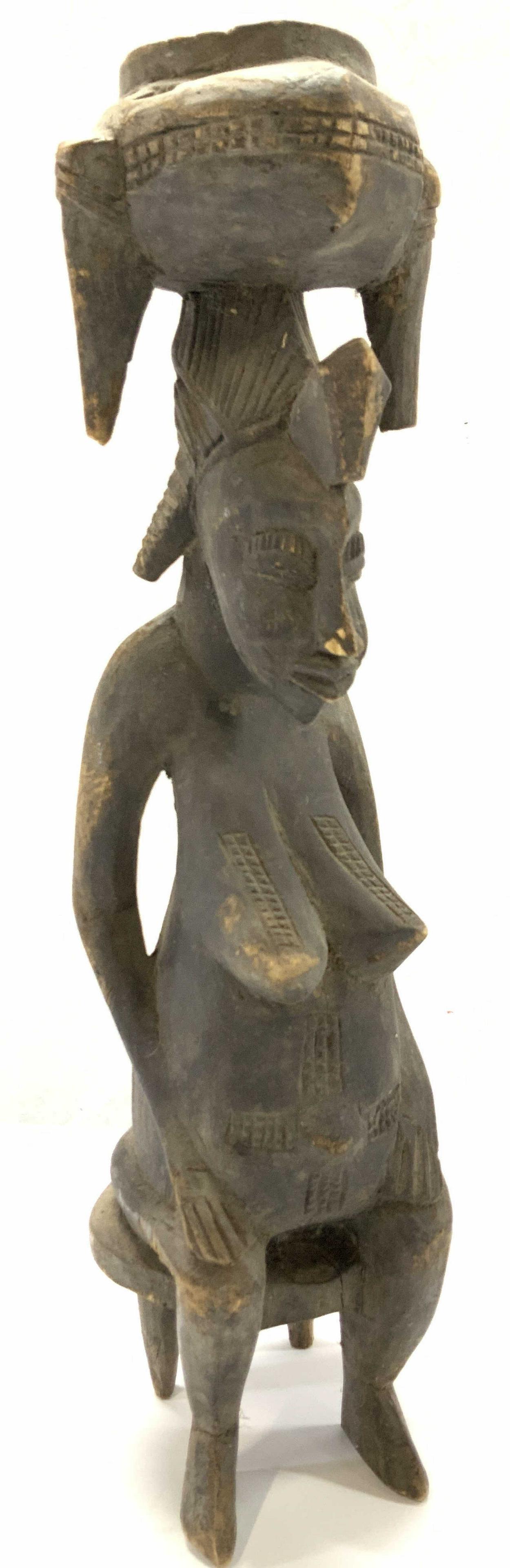 Antique African Art Wood Sculpture, Pregnant Woman: African tribal ethnographic wood sculpture of a seated present nude woman balancing a basket on her head, she is pregnant and her face and body have ritual scarification marks, possibly Senufo Peoples
