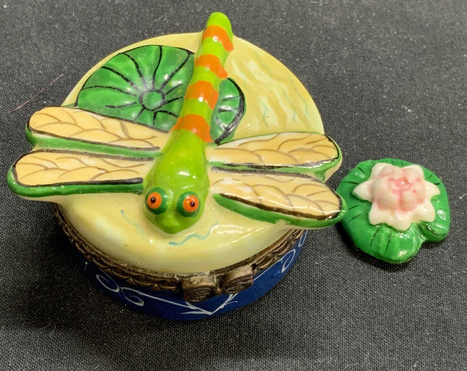 Porcelain Dragonfly Pill Box & Lily Pad Trinket: Porcelain pill box with dragonfly motif and Lily pad trinket. Pill box measures approx. 1.5 inches diameter and 1 inch tall. Lily pad trinket measures approx. .75 inches diameter. Some surface wear co