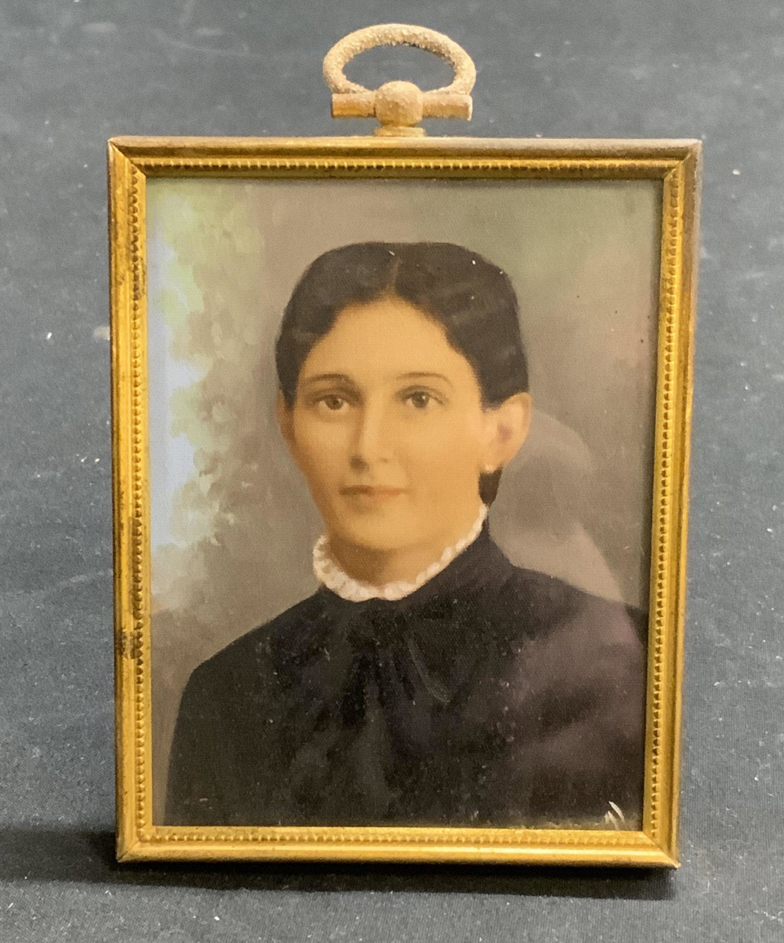 Brass Picture Frame with Antique Portrait: Brass picture frame with possibly antique portrait of a woman. Not examined out of frame. Appears to be painted. Signature to lower right, illegible. Frame measures approx. 2.75 x 3.5 inches. Brass pi