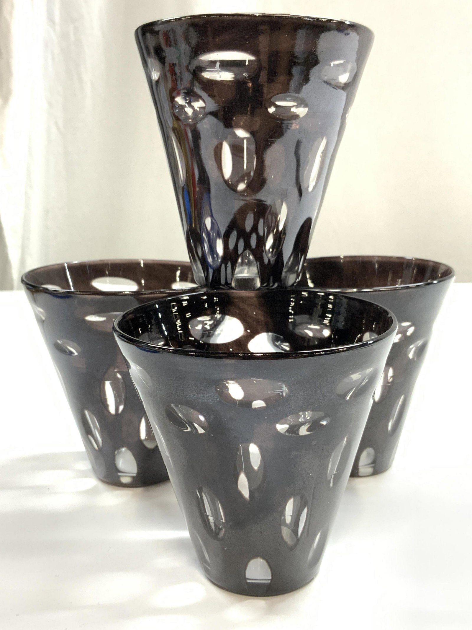 MARGARET BURKE Set 4 Art Glass Vessels UK: Lot includes 4 Art glass vessels each signed M BURKE MADE IN UK on underside. Each piece has clear ellipse pattern detail. Each measures approx 3.75 inches tall 3 inches wide. Art glass, art glass ves