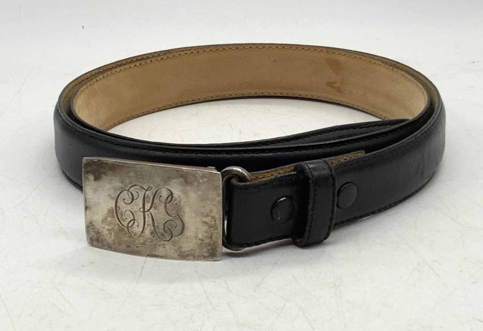 TIFFANY Black Leather Belt & STERLING SLV Buckle: Tiffany black leather belt and sterling silver belt buckle with engraved initials CKG. Belt size 34. Designer label to leather. Marked sterling to buckle. Total weight of sterling .94 ozt. Some wear t
