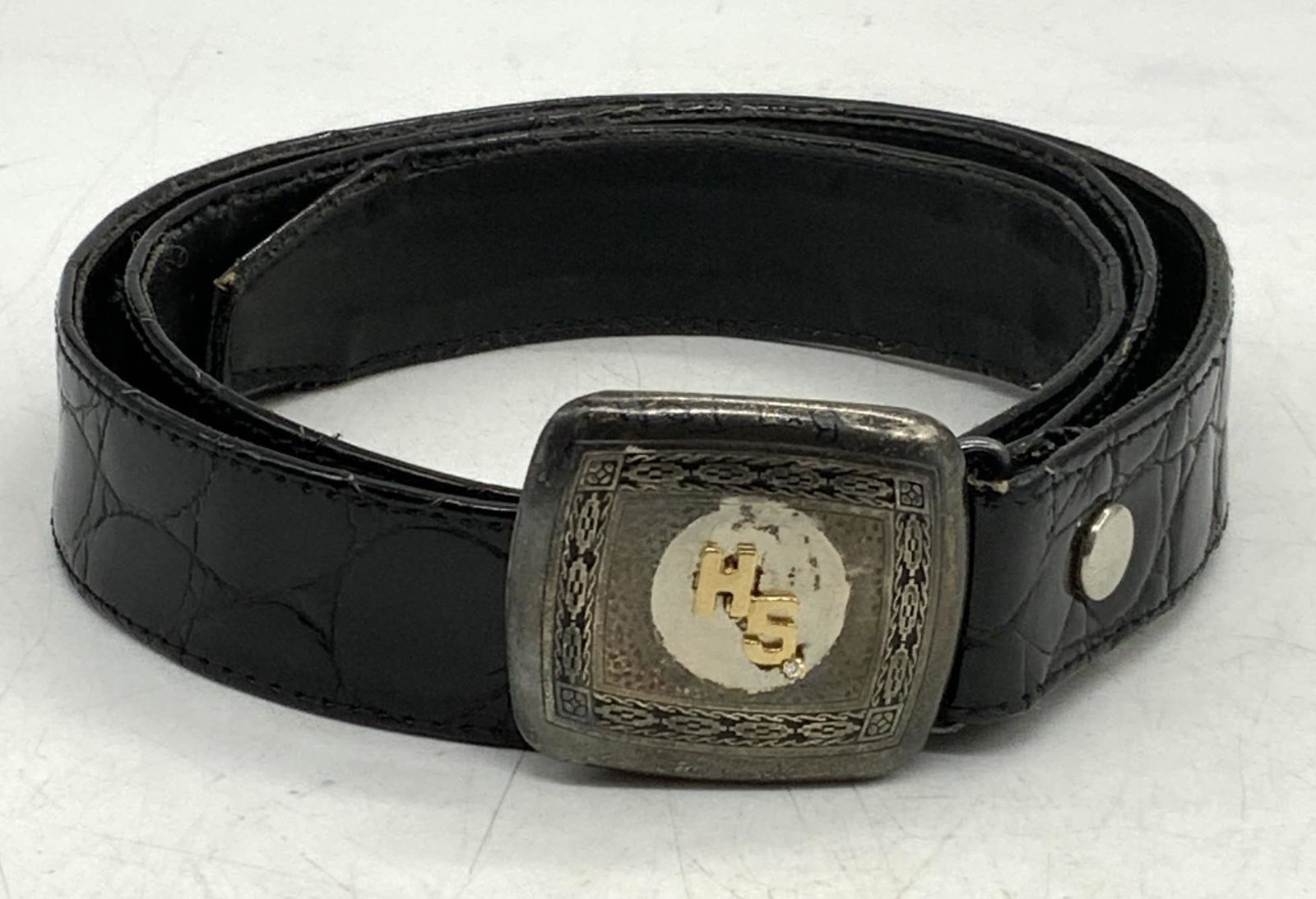 HIGKOK Sterling Silver Buckle & Black Leather Belt: Signed HIGKOK sterling silver belt buckle with HS monogram and crystal decoration. Marked HIGKOK, sterling to underside. Total weight approx. .70 ozt. Black leather belt. Measures approx. 37.5 inches 