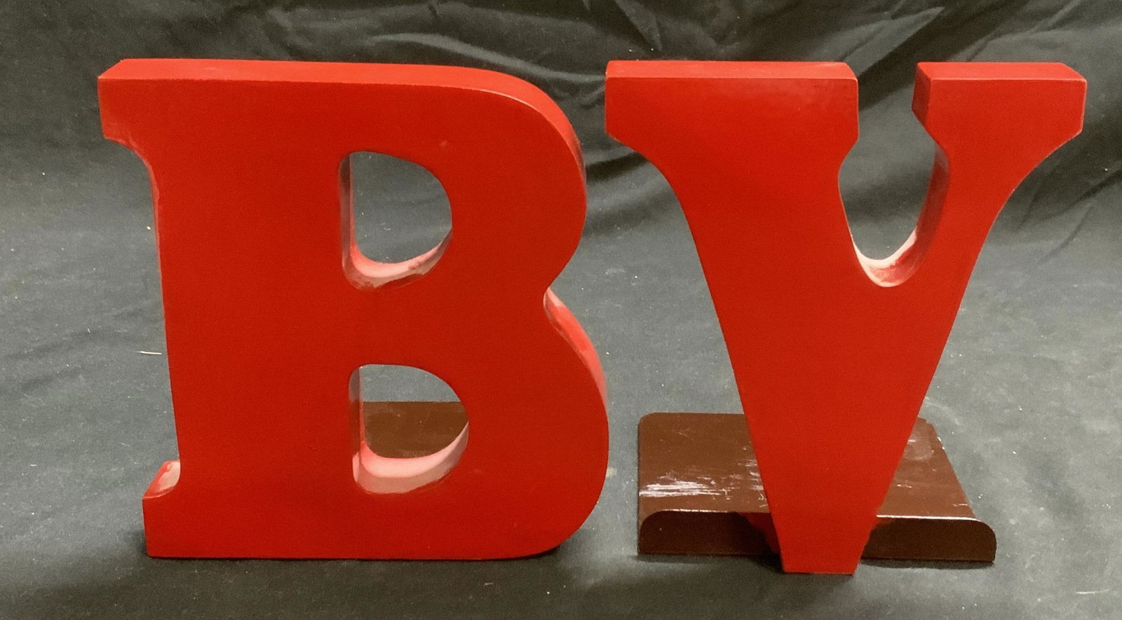 B & V Red Painted Wood Bookends: B & V initial hand painted wood bookends in red. Some surface wear consistent with exposure. Sizes vary, B measures approx. 5 x 4.5 x 5.5 inches, V measures approx. 4 x 4.5 x 5.5 inches. Bookends, ini