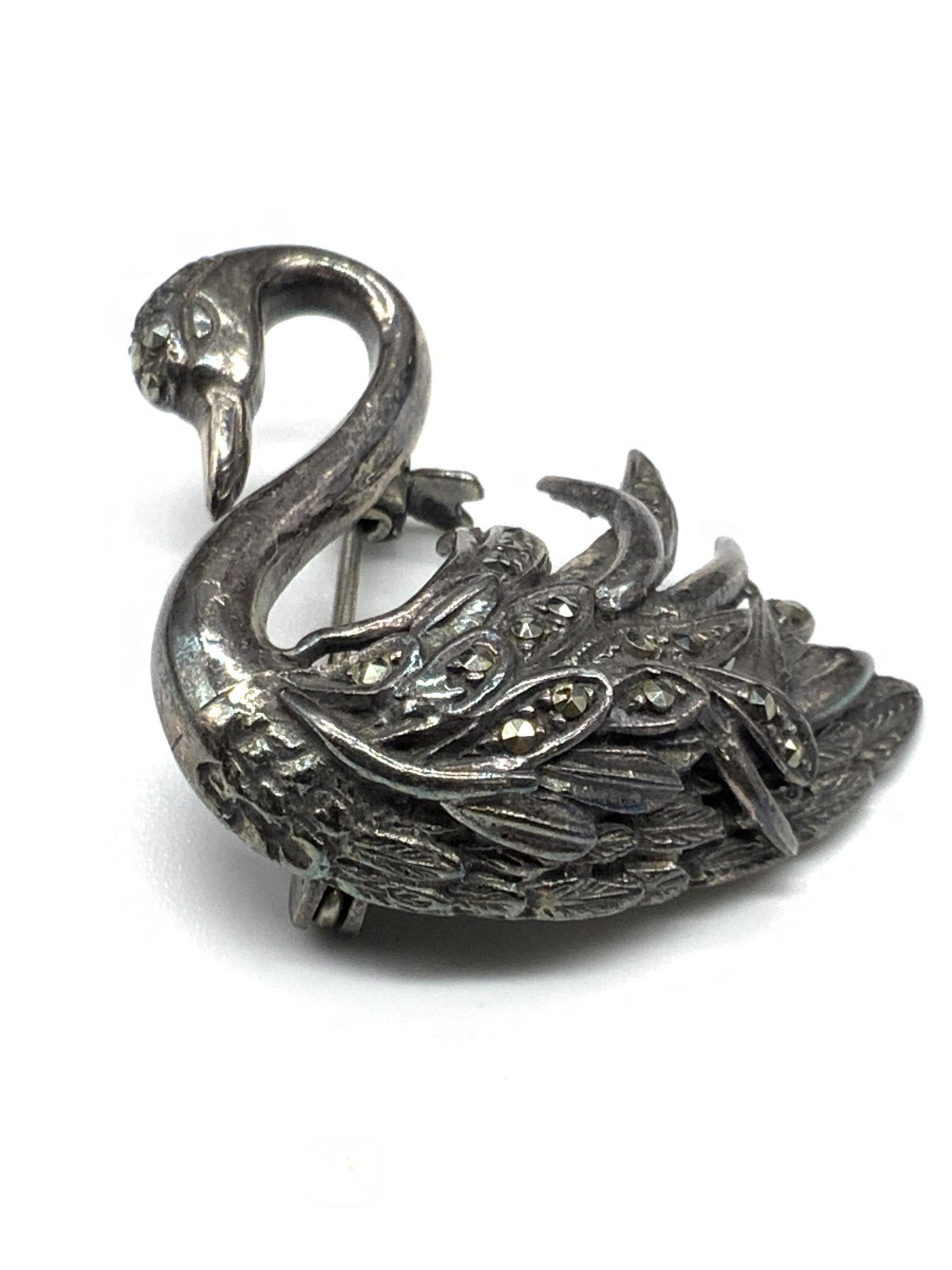 STERLING SILVER Marcasite Swan Form Vintage Brooch: A vintage sterling silver swan form brooch studded with marcasite. Etched metalwork accents throughout. Metal pin closure to reverse. Reverse stamped 925. Measures approx 1.5L x 1.5W in. Total weight 