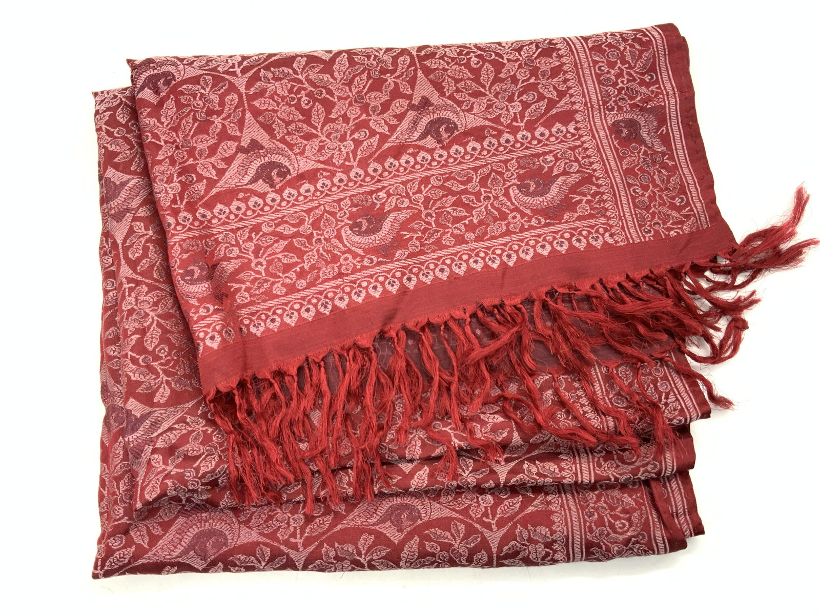 100% Silk Hand Woven Fringe Scarf, India: Red toned fringe scarf with white embroidered floral motifs throughout. Marked on tag 100% Silk, Hand woven, made in India. Approximately 60 inches long and 21 inches wide. Minor pulled threading. Han