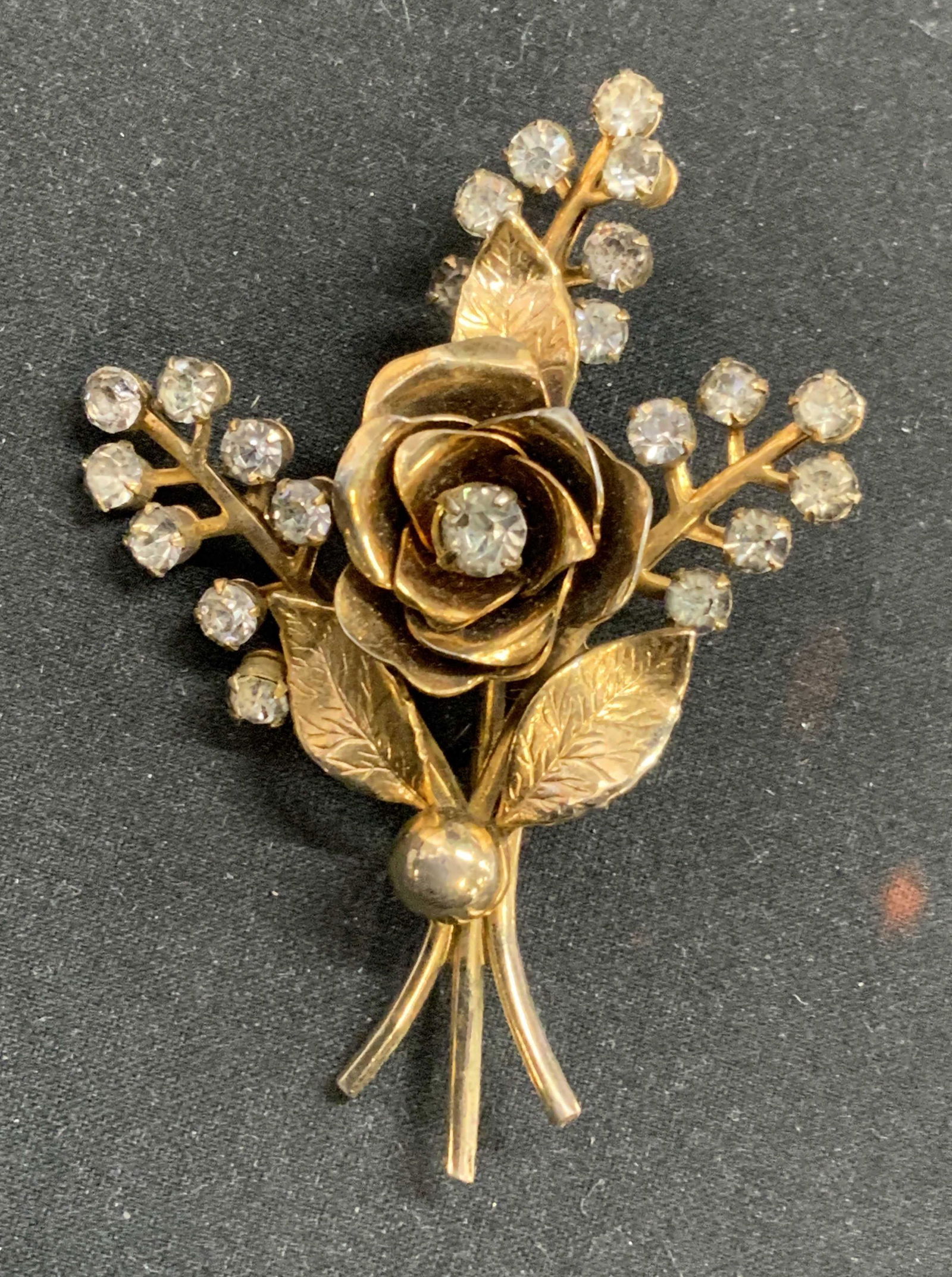 CORO Vintage Gold Tone Floral & Crystal Brooch: Coro vintage gold tone rose brooch with colorless faceted crystal decoration. Measures approx. 2.5 x 2 inches. Designer hallmark to underside. Hinge pin backing. Some surface wear consistent with expo