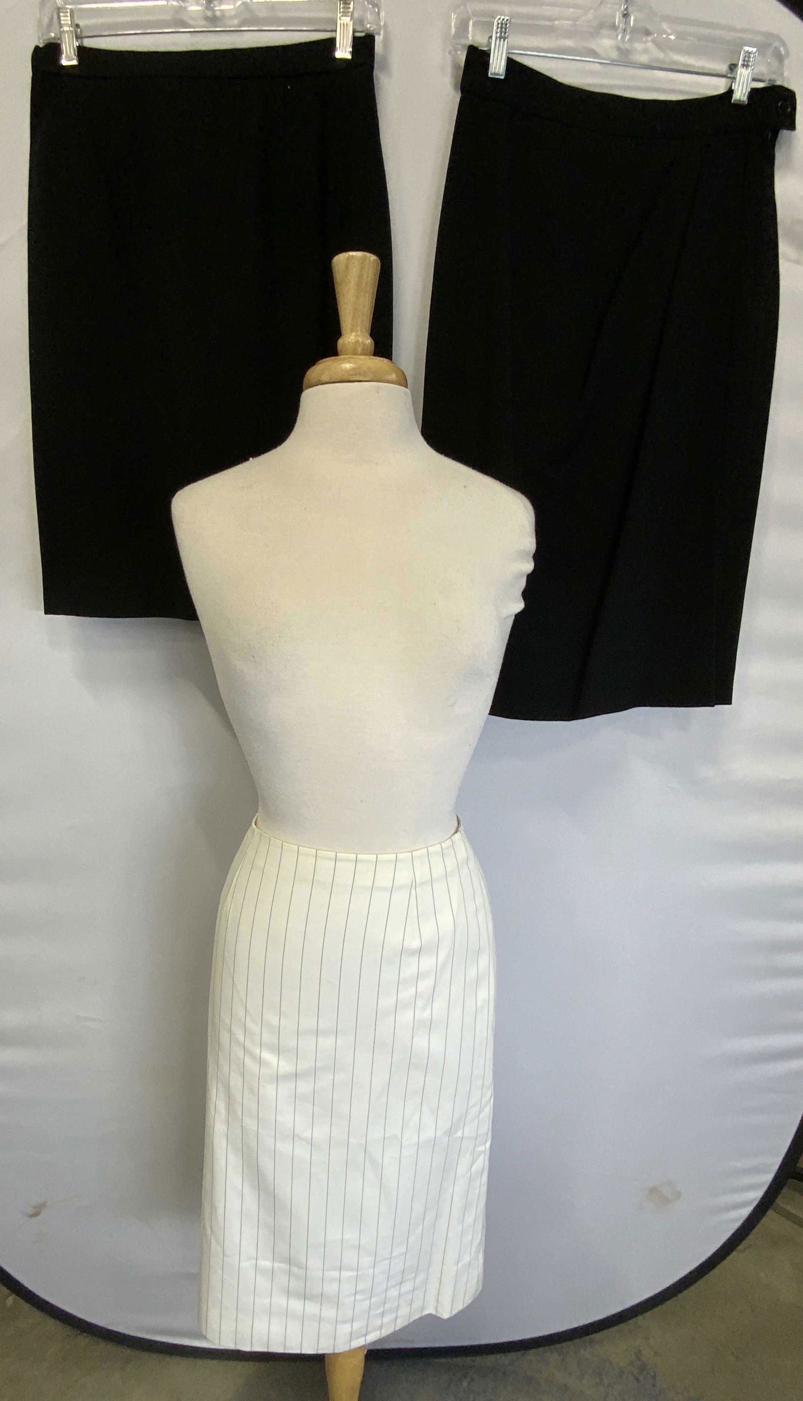 Lot 3 Designer Skirts, YVES SAINT LAURENT & More: Lot of 3 designer skirts/suit separates. Includes Yves Saint Laurent white pinstripe cotton skirt, size 38, Anne Klein black wool skirt, size 8, and Max Mara black wool skirt, size 8. All pieces gentl