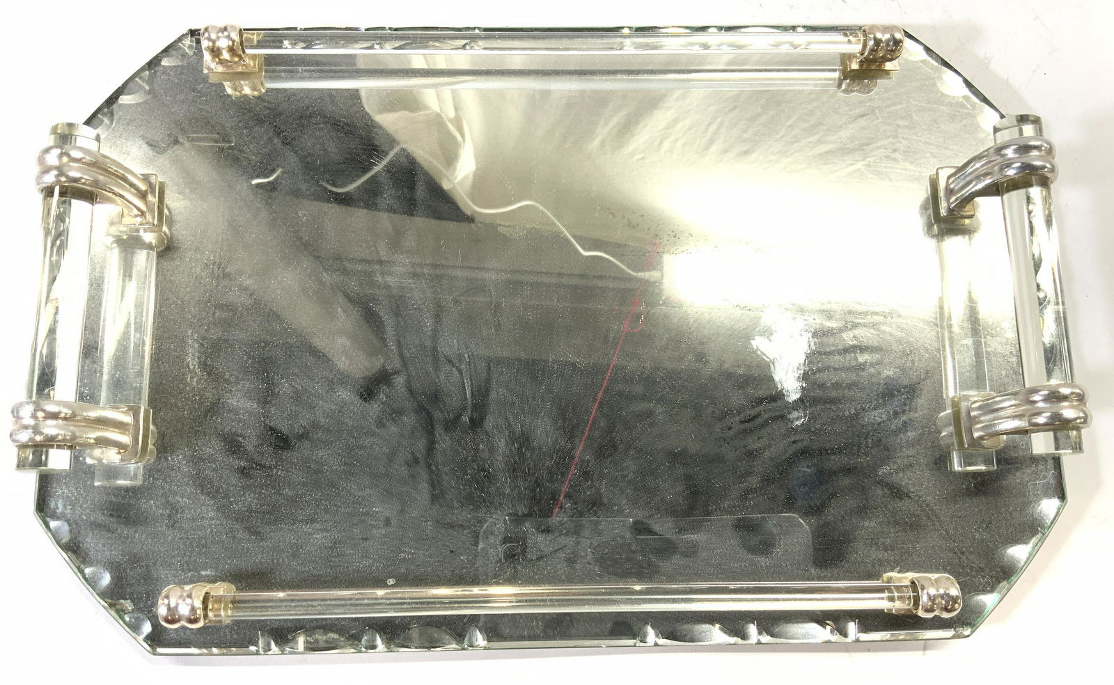 NOVA LYON VILLEURBANNE Vanity Tray Lucite Handles: Underside has tag which reads NOVA LYON VILLEURBANNE. Vanity tray is mirrored. Piece has cylindrical lucite handles. Some areas of gray have geometric beveling. Piece measures approx 17 inches long 10