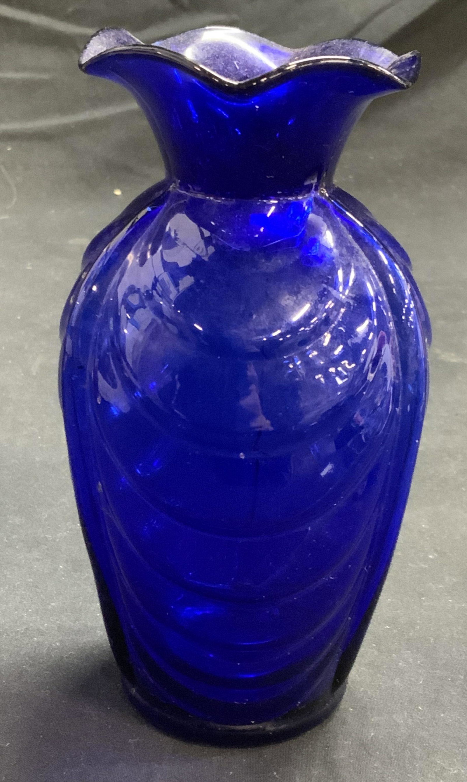 Cobalt Glass Embossed Bud Vase: Cobalt glass Bud vase with embossed rib pattern to body. Measures approx. 3 inches diameter and 5.5 inches tall. Surface wear consistent with exposure. Cobalt glass, blue glass, Bud vase, vase, glass 