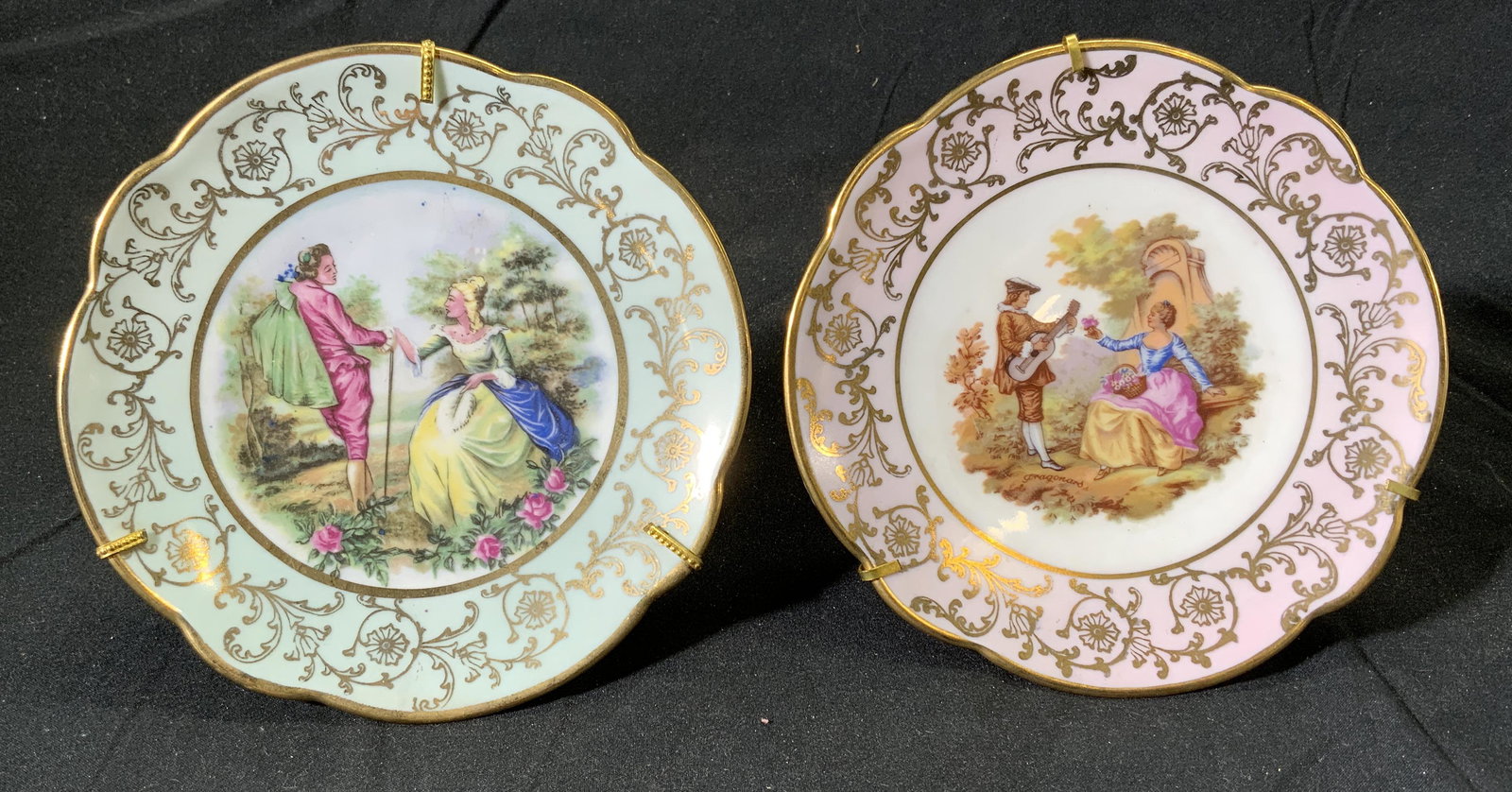 Set 2 Antique LIMOGES Gilt Porcelain Plates FRANCE: Set of 2 antique Limoges France porcelain plates, Hand painted with gilt decoration and figural motifs to center. Trademarked to undersides. Includes plate stands. Plates measure approx, 5 inches diam