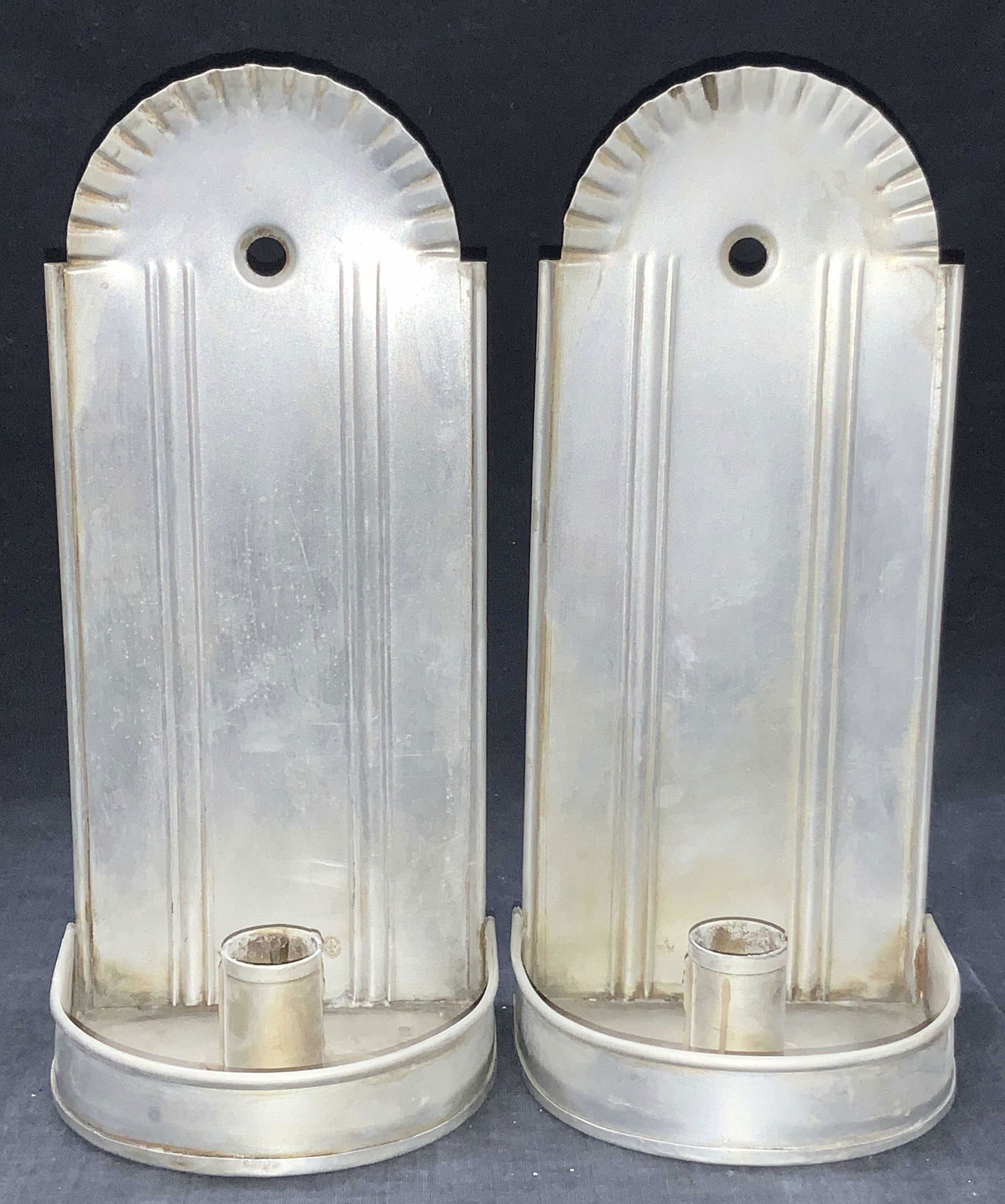 Virginia Metalcrafters Pewter Wall Candle Holders: Pair of pewter made wall candle holders with crimped tops to back panels. Marked on backside Virginia Metal Crafters Inc. Approximately 9.75 inches tall. Evident wearing due to previous use. Virgins m