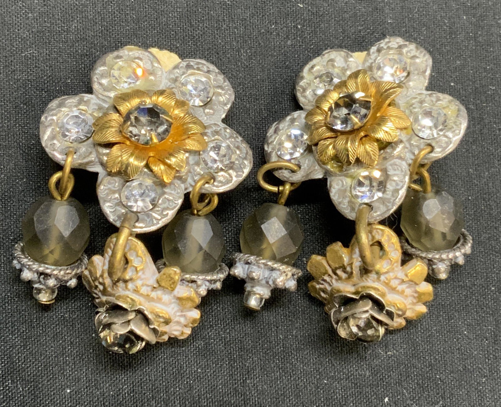 Vintage Parisian Chandelier Clip On Earrings: Vintage Parisian chandelier floral form clip on dangle earrings with crystal decoration. Surface wear consistent with exposure. Measure approx. 1 inch wide and 1.75 inches long. Estate jewelry, costum
